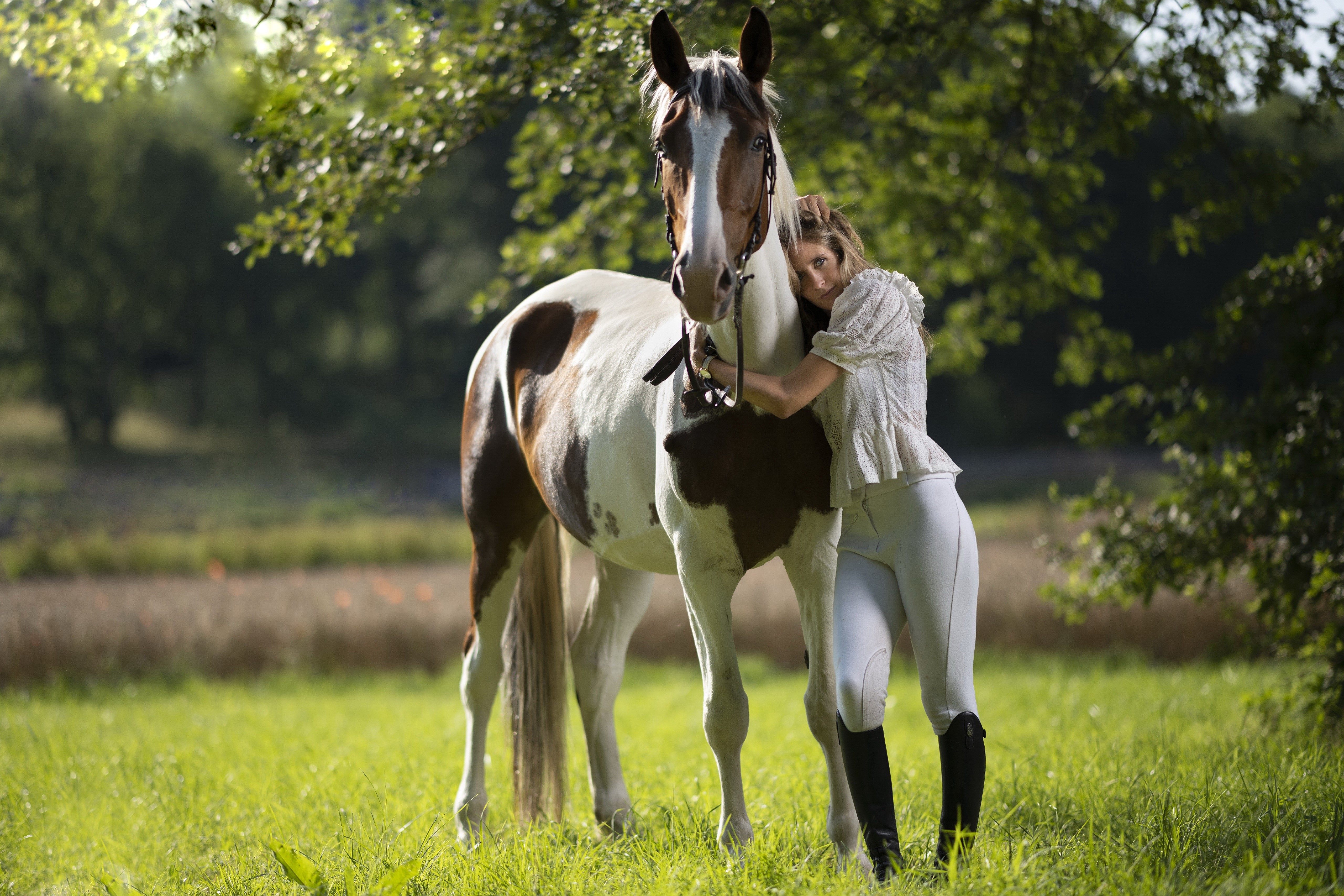 Woman hugging a brown and white horse in a field HD Wallpaper