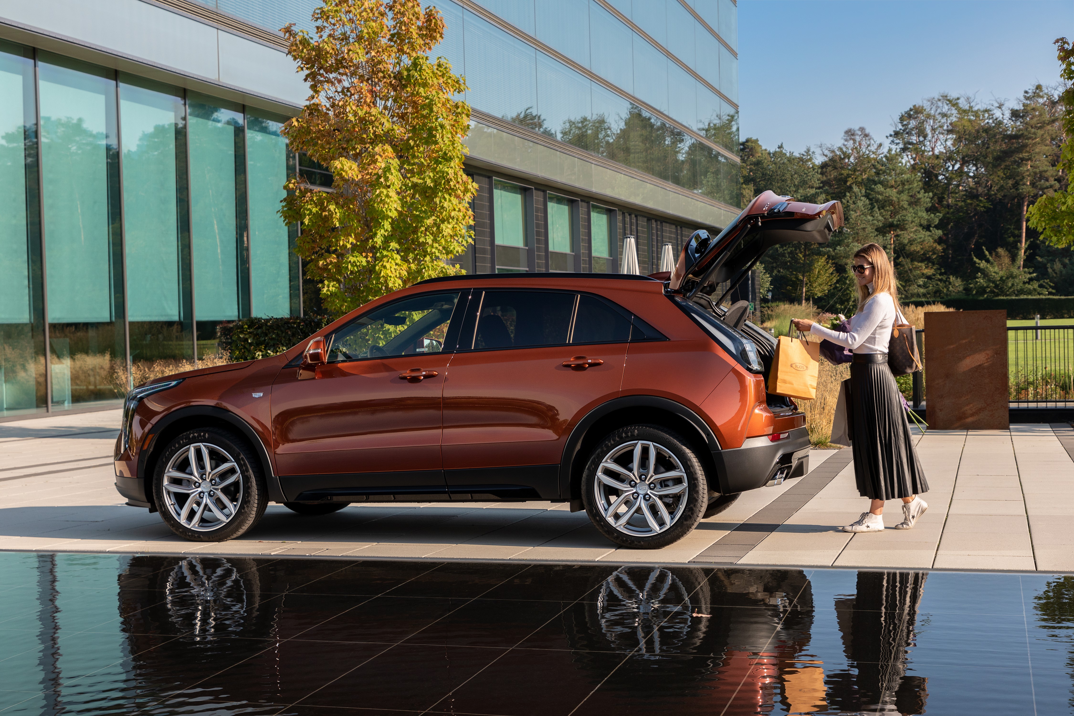Cadillac XT4 Crossover with woman and shopping bags HD Wallpaper