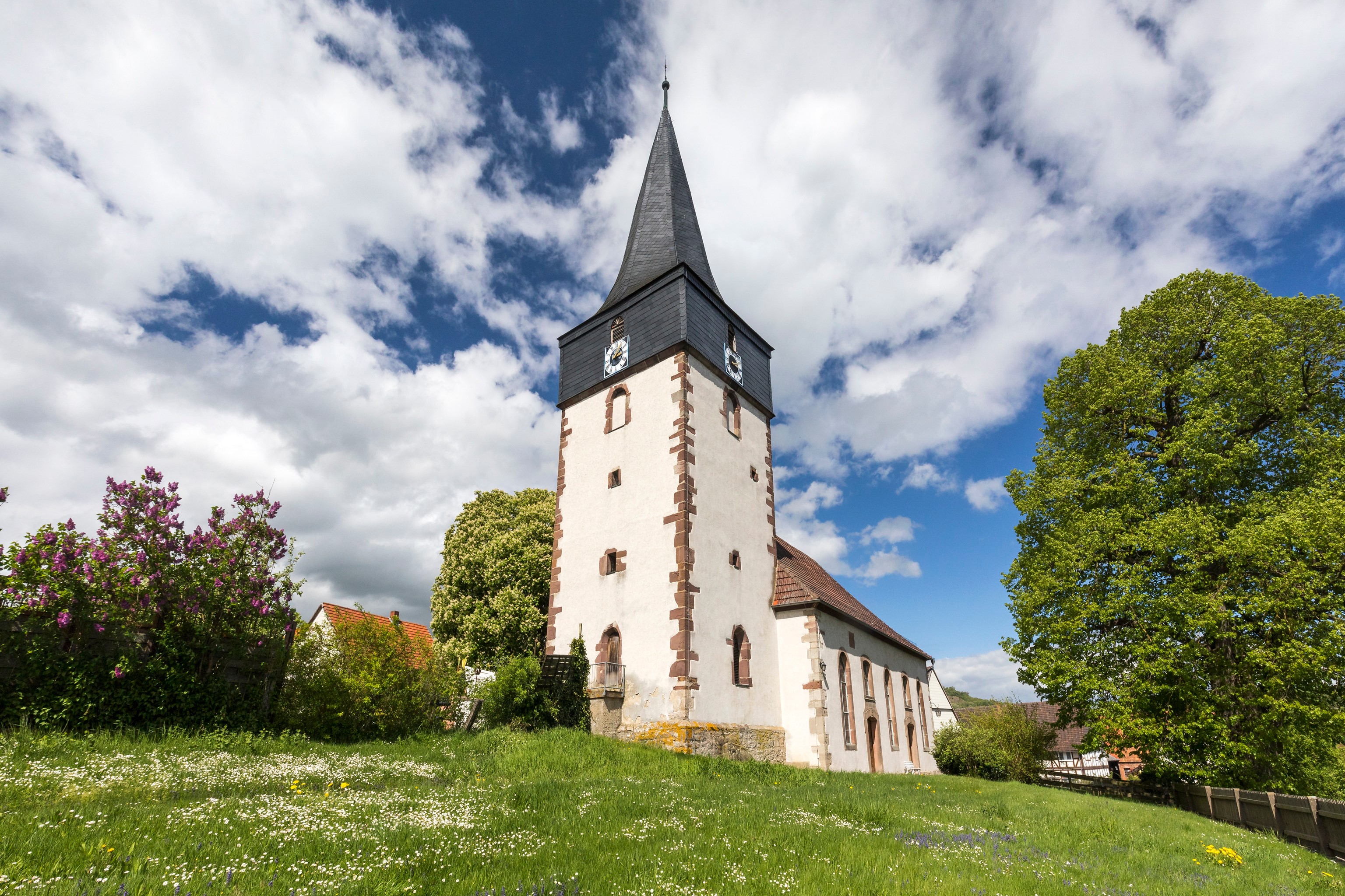 Church tower in a German village with a cloudy sky HD Wallpaper