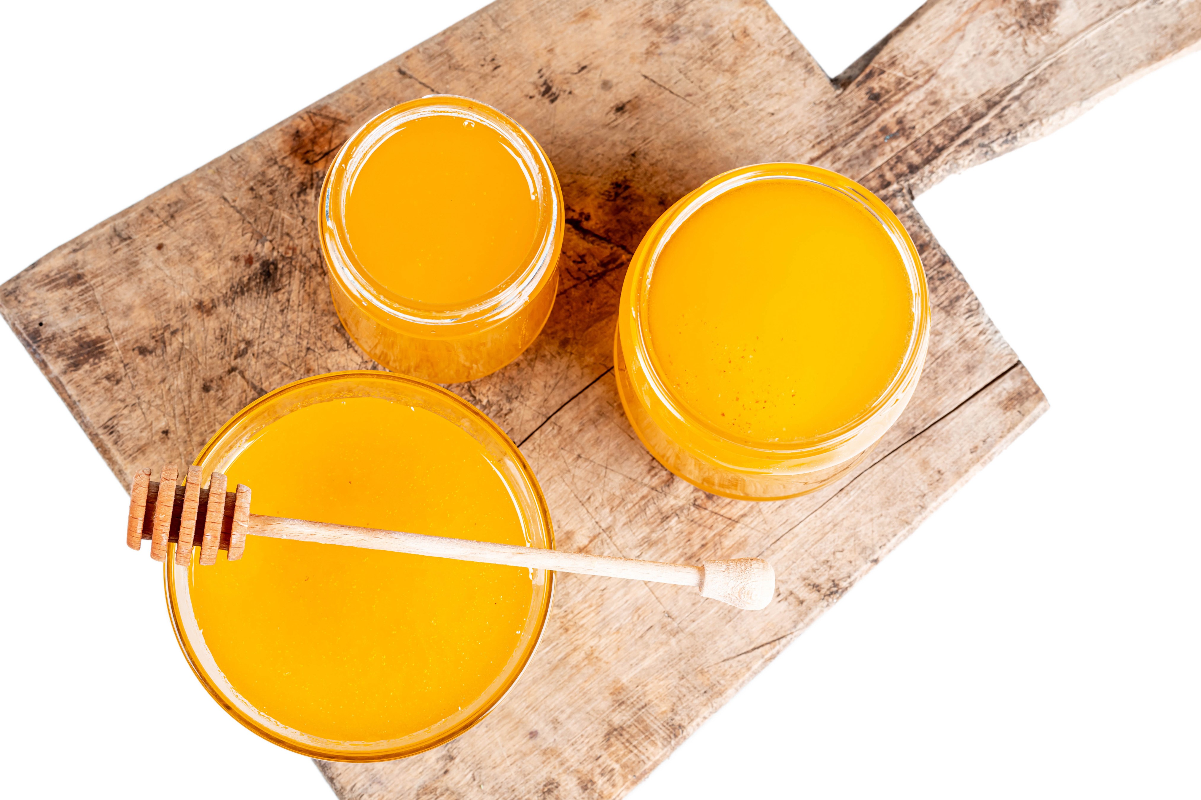 Honey jars on a wooden cutting board HD Wallpaper