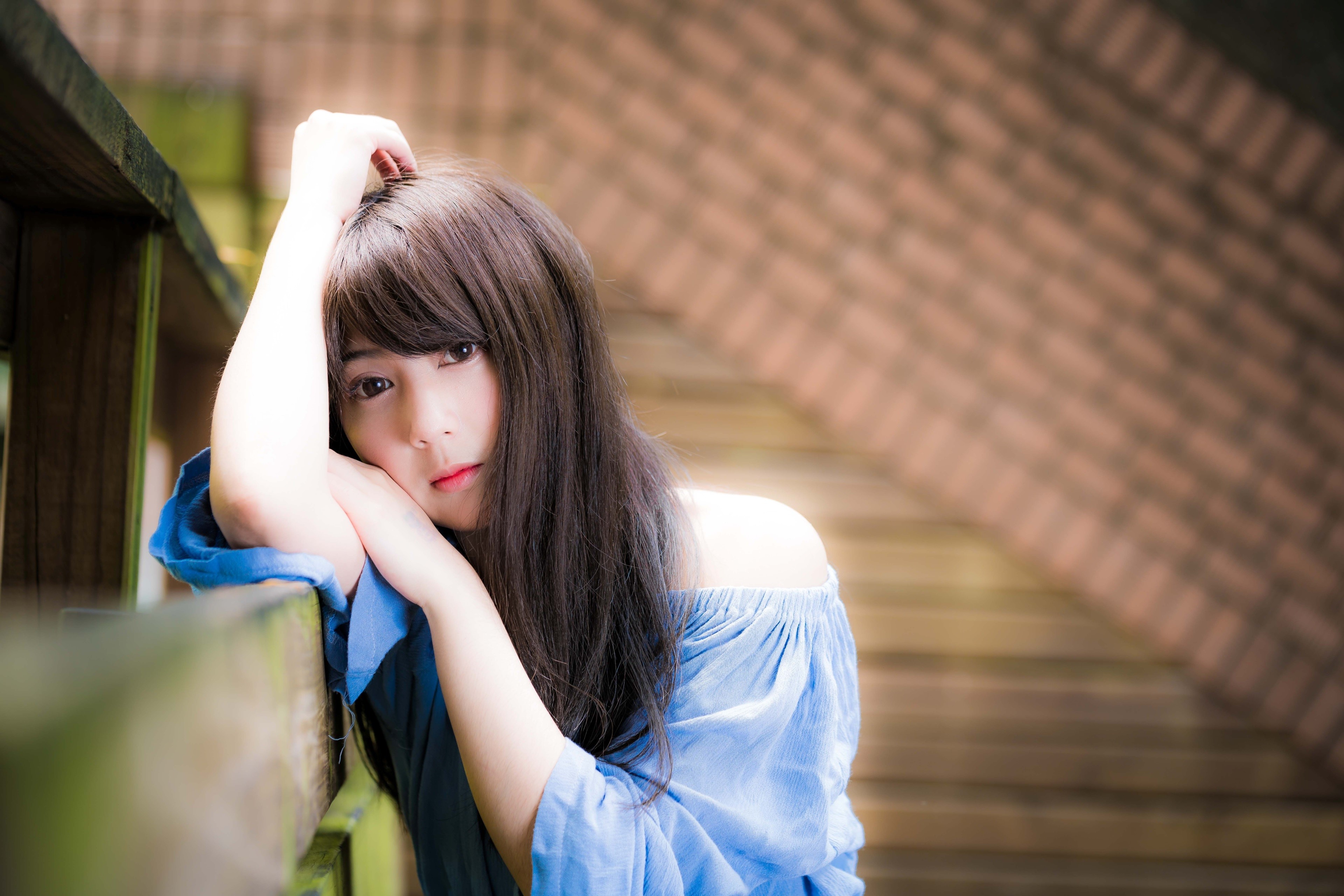 Asian woman with brown hair leaning on a railing HD Wallpaper