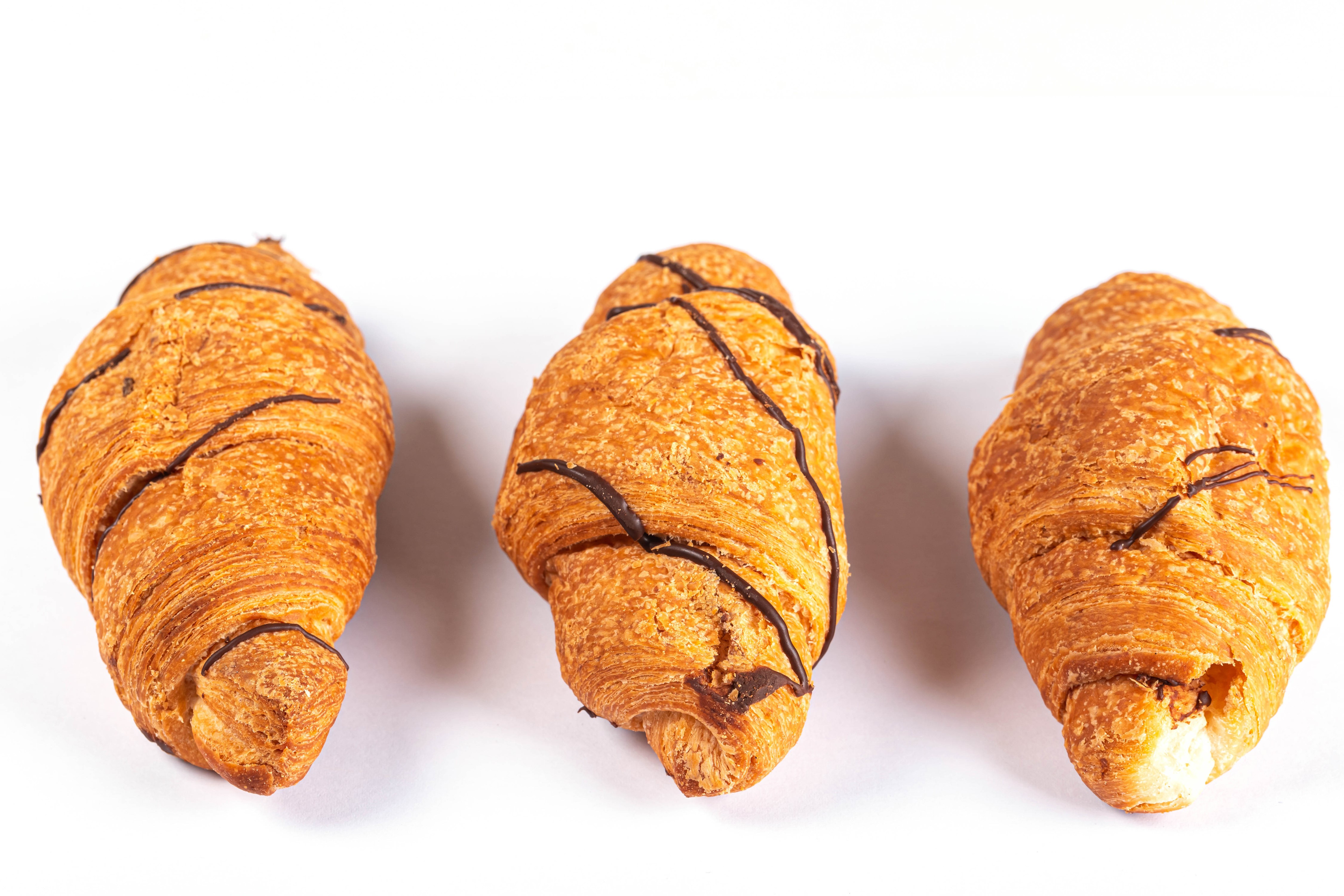Three chocolate drizzled croissants on white background HD Wallpaper