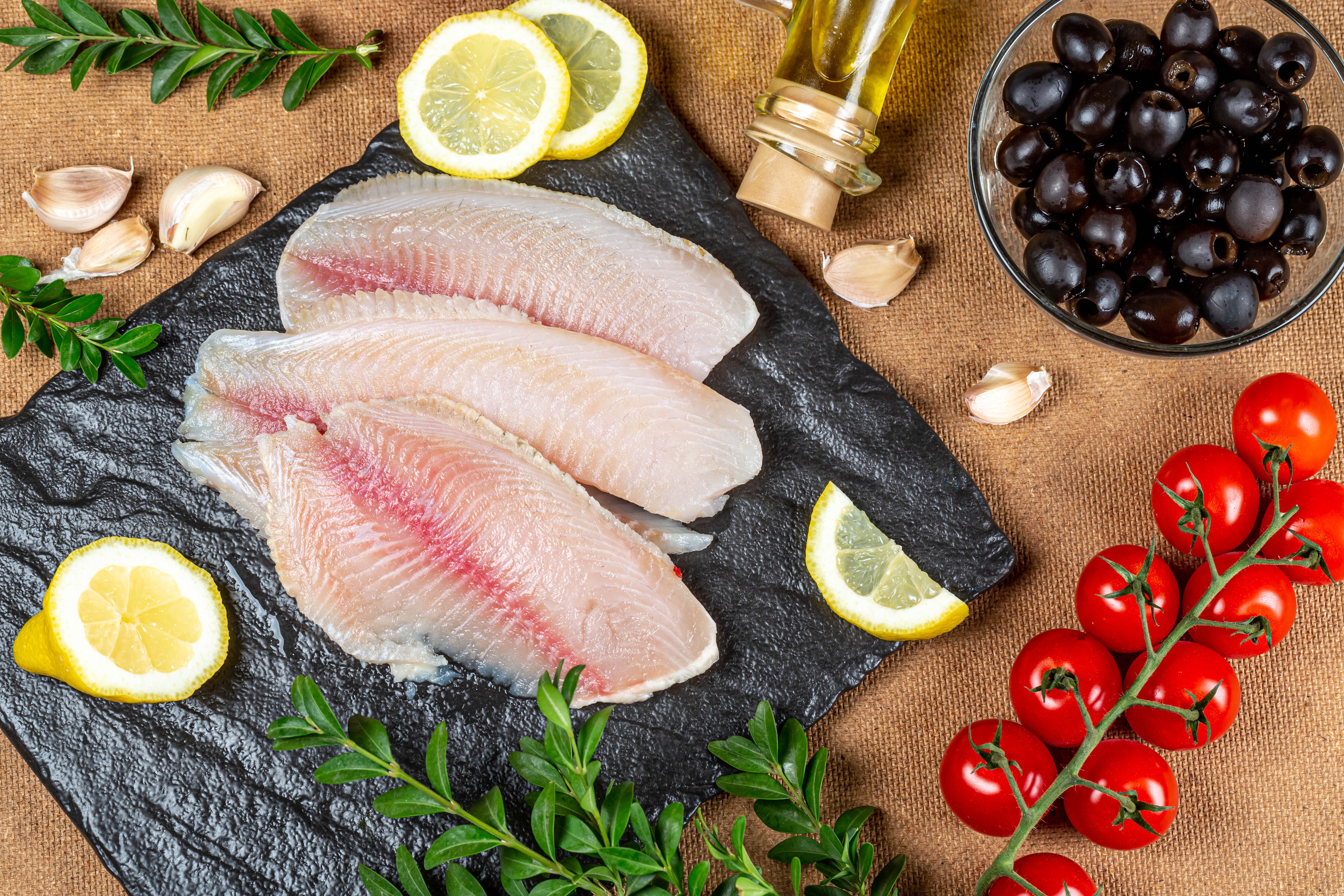 Raw Fish Fillets with Tomatoes, Olives, Lemons, and Garlic HD Wallpaper