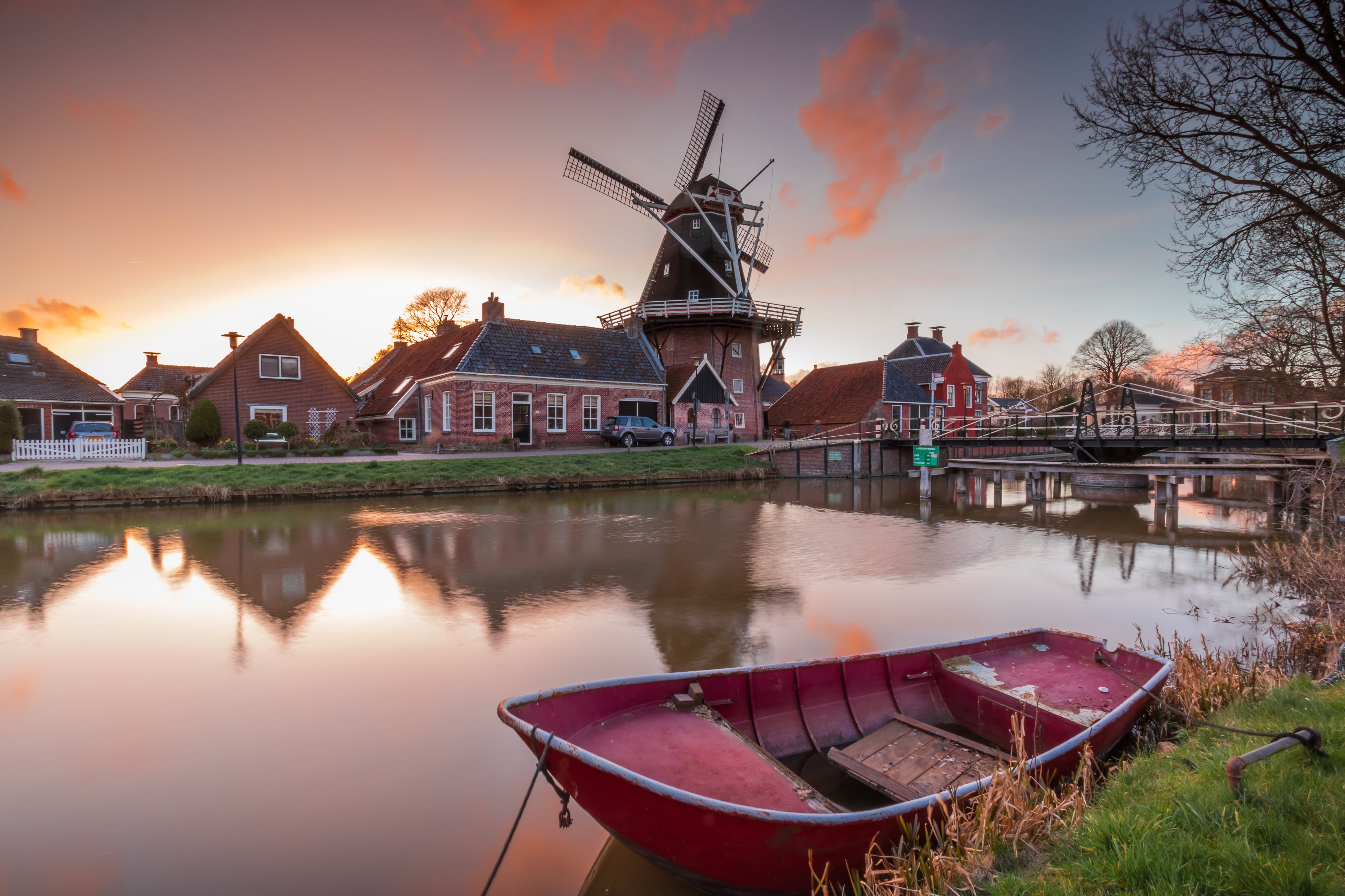 Canal with windmill, houses, and boat in Groningen, Netherlands HD Wallpaper