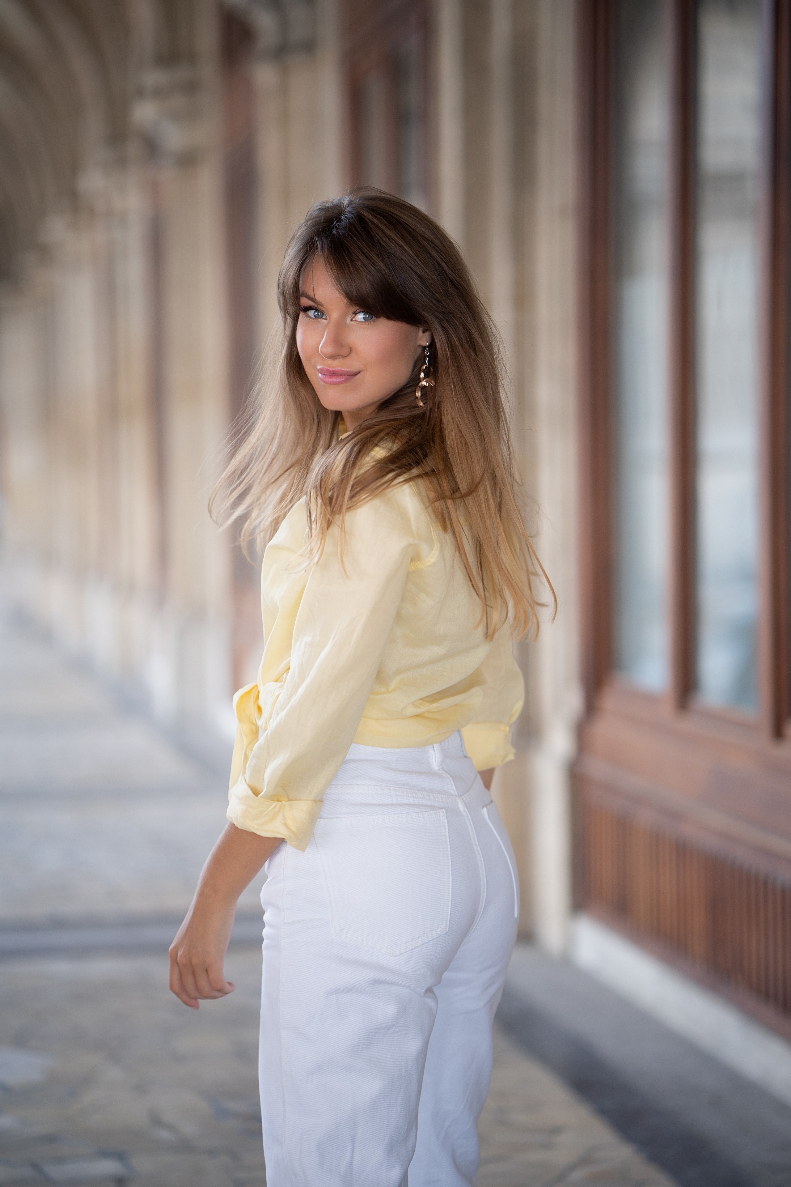Alina wearing a yellow shirt and white trousers HD Phone Wallpaper