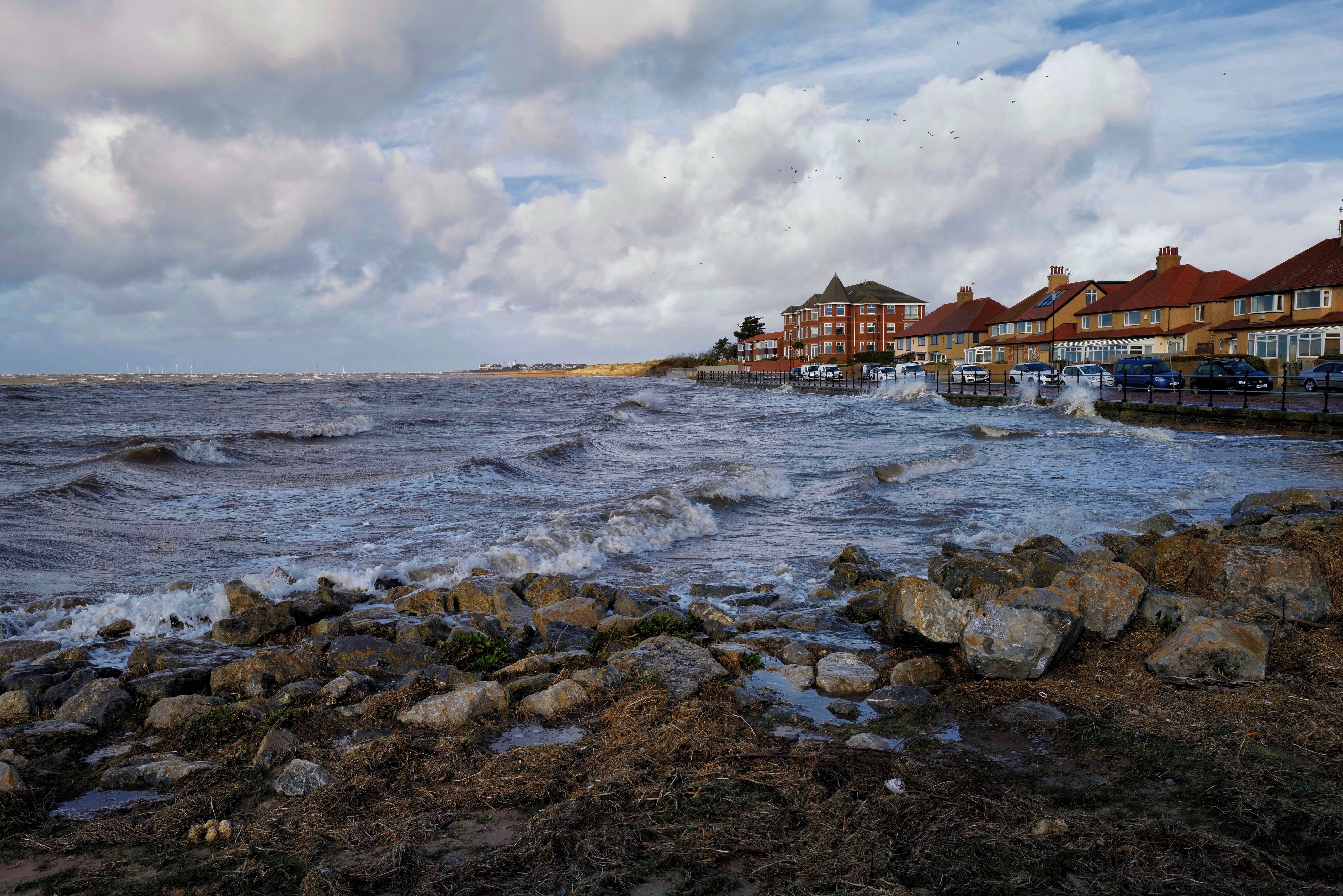 Waves crashing on the coast near houses in Wirral, England HD Wallpaper