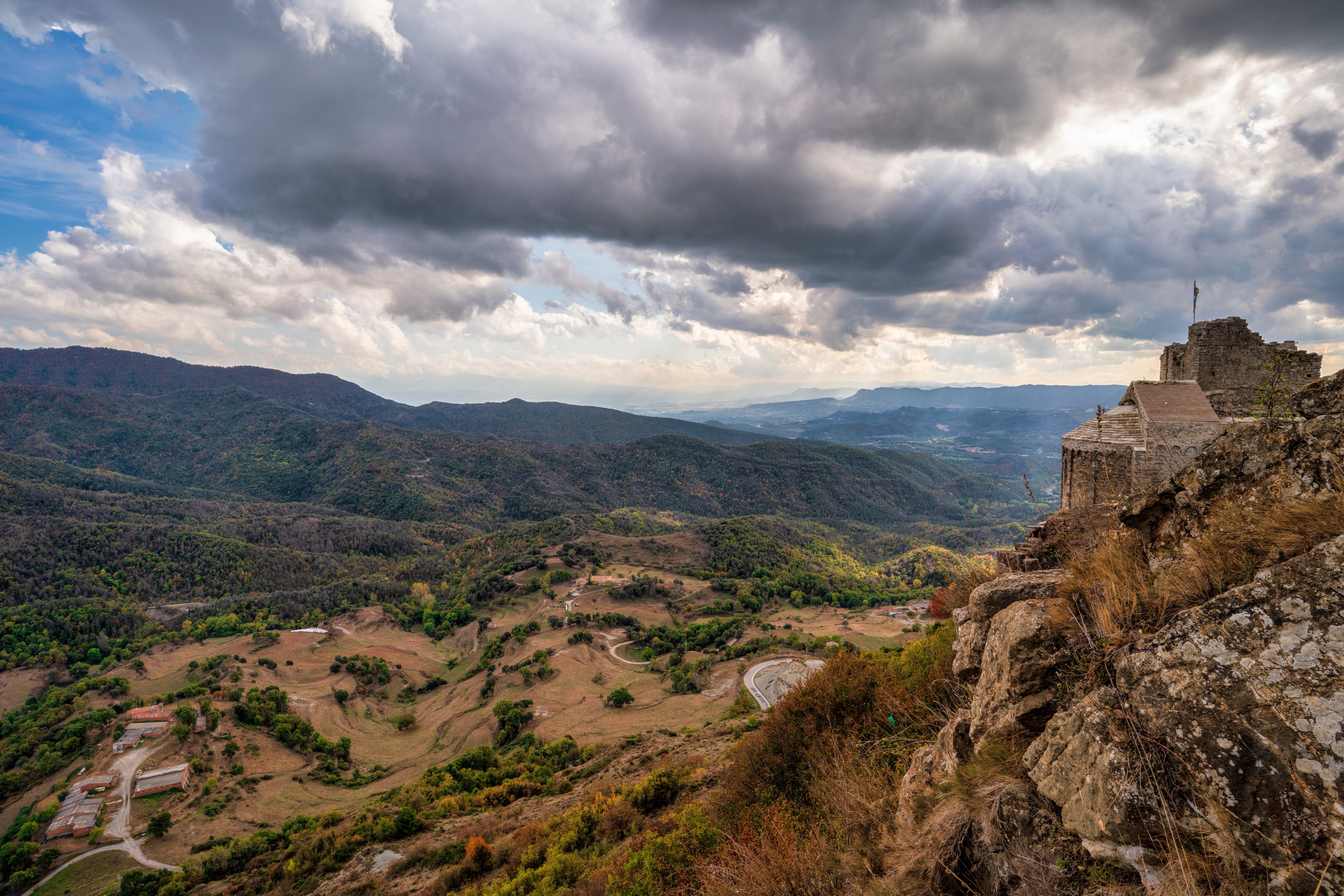 Castle ruins on a rocky outcrop overlooking mountains in Catalonia, Spain HD Wallpaper