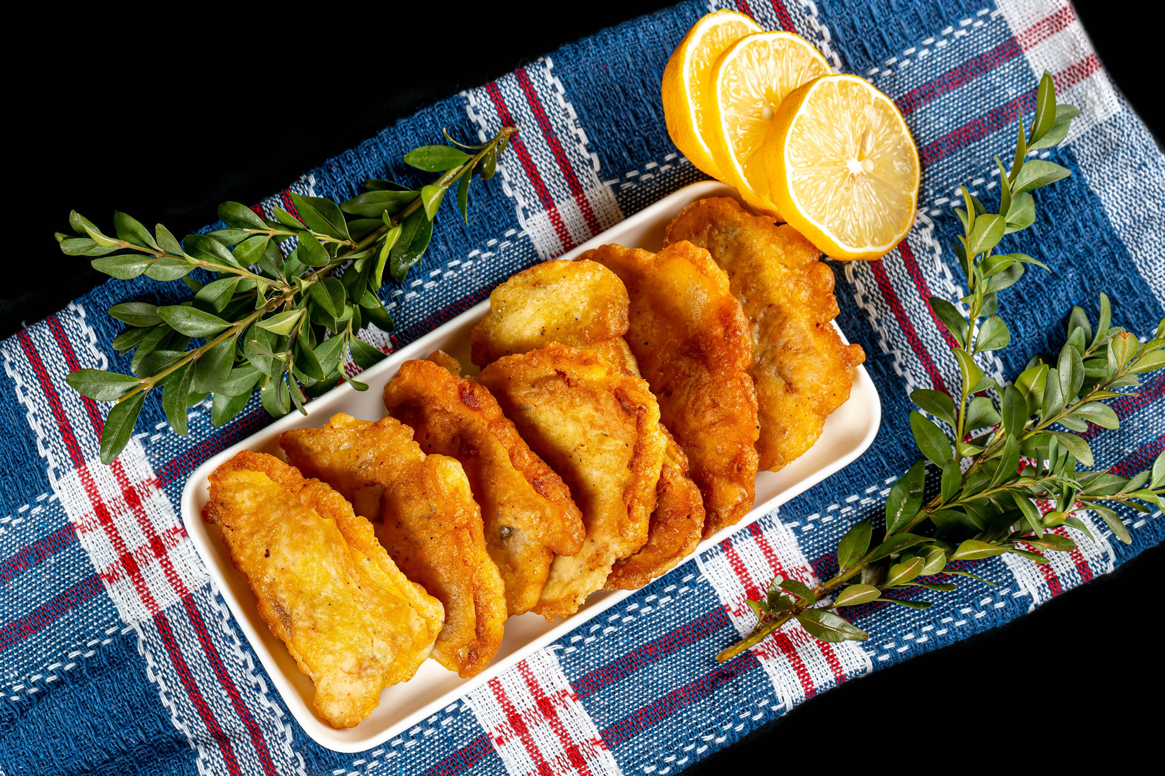 Fried fish with lemon slices and greenery HD Wallpaper