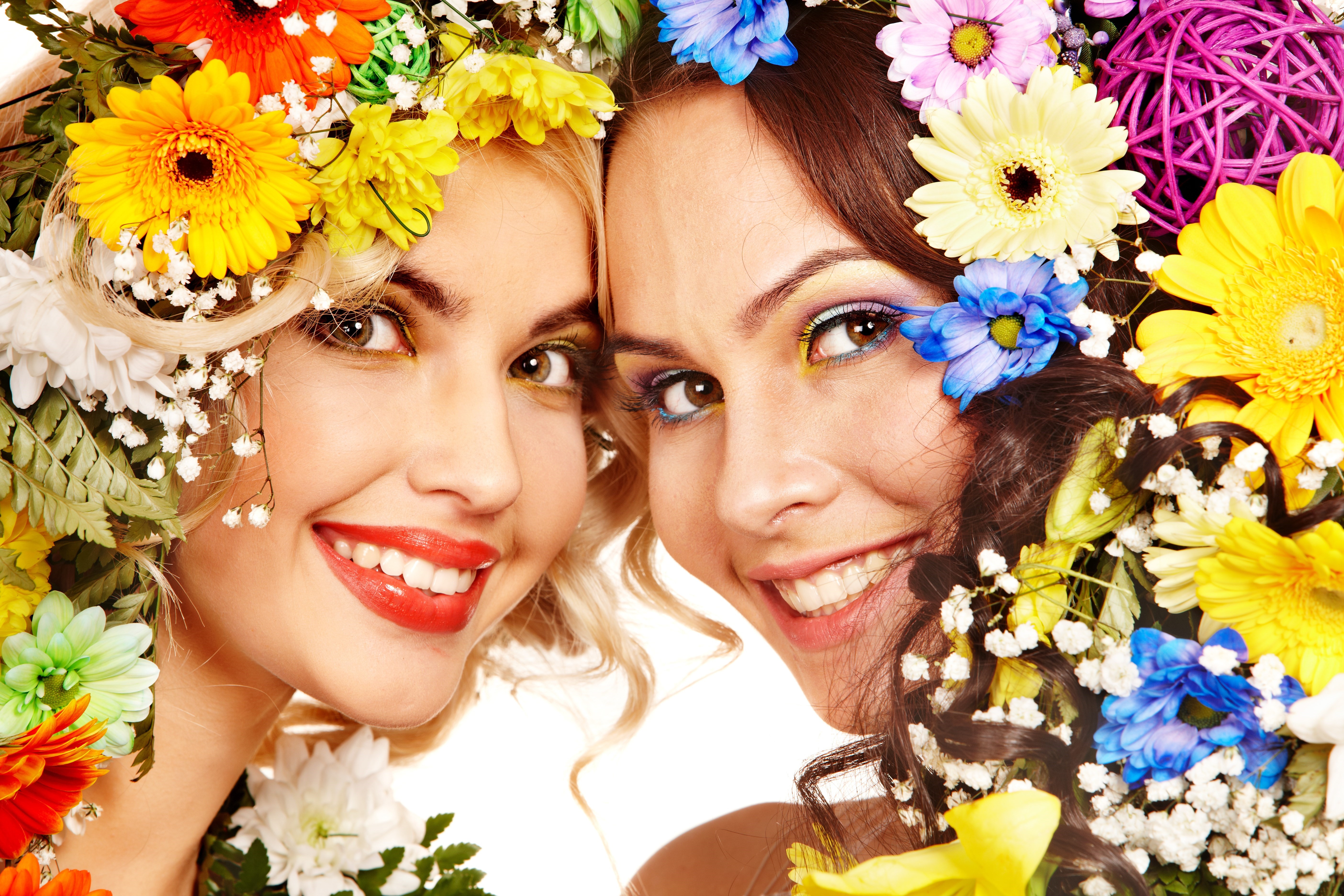 Two women with flower wreaths smiling HD Wallpaper