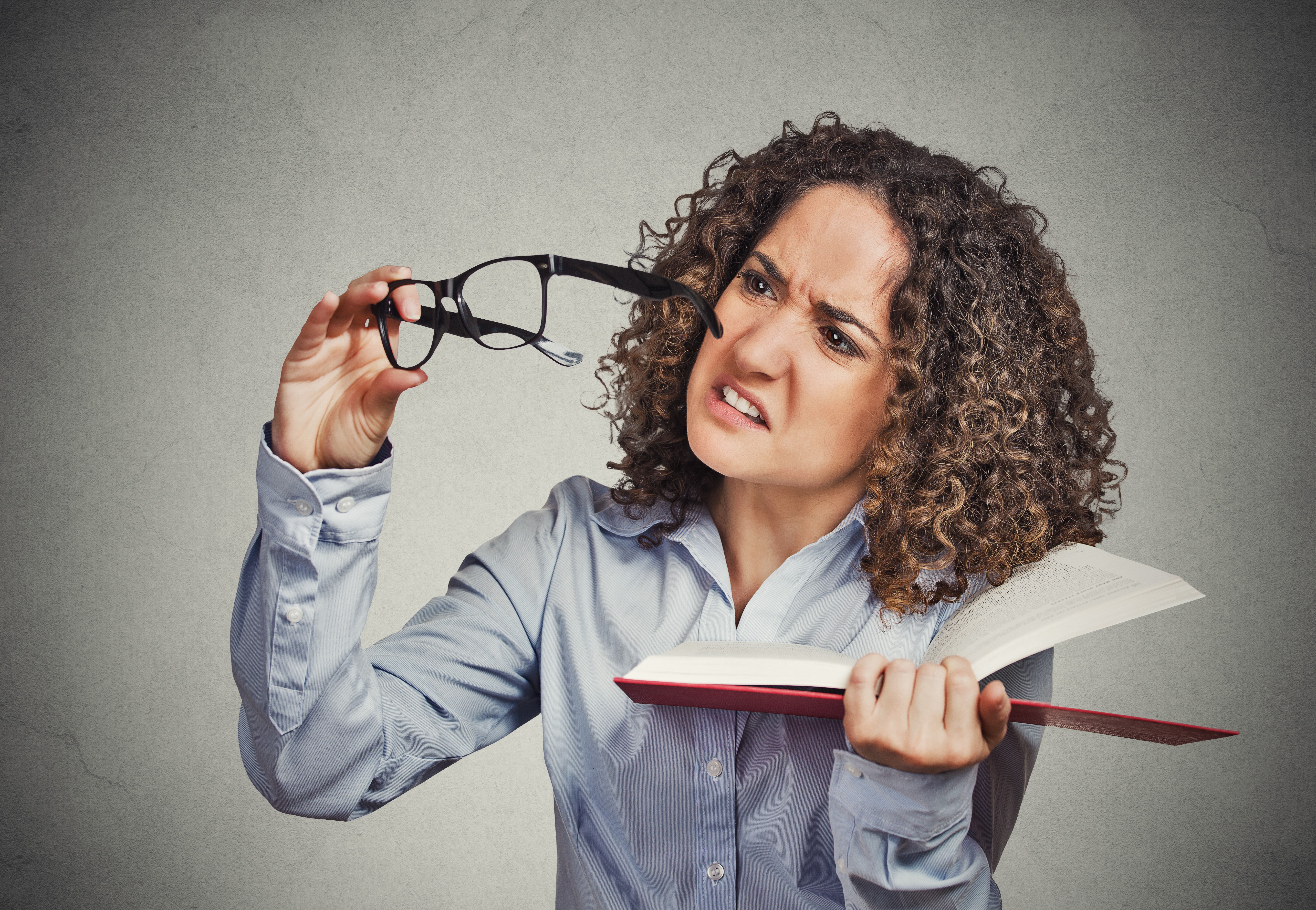 Woman with curly hair holding glasses and book HD Wallpaper