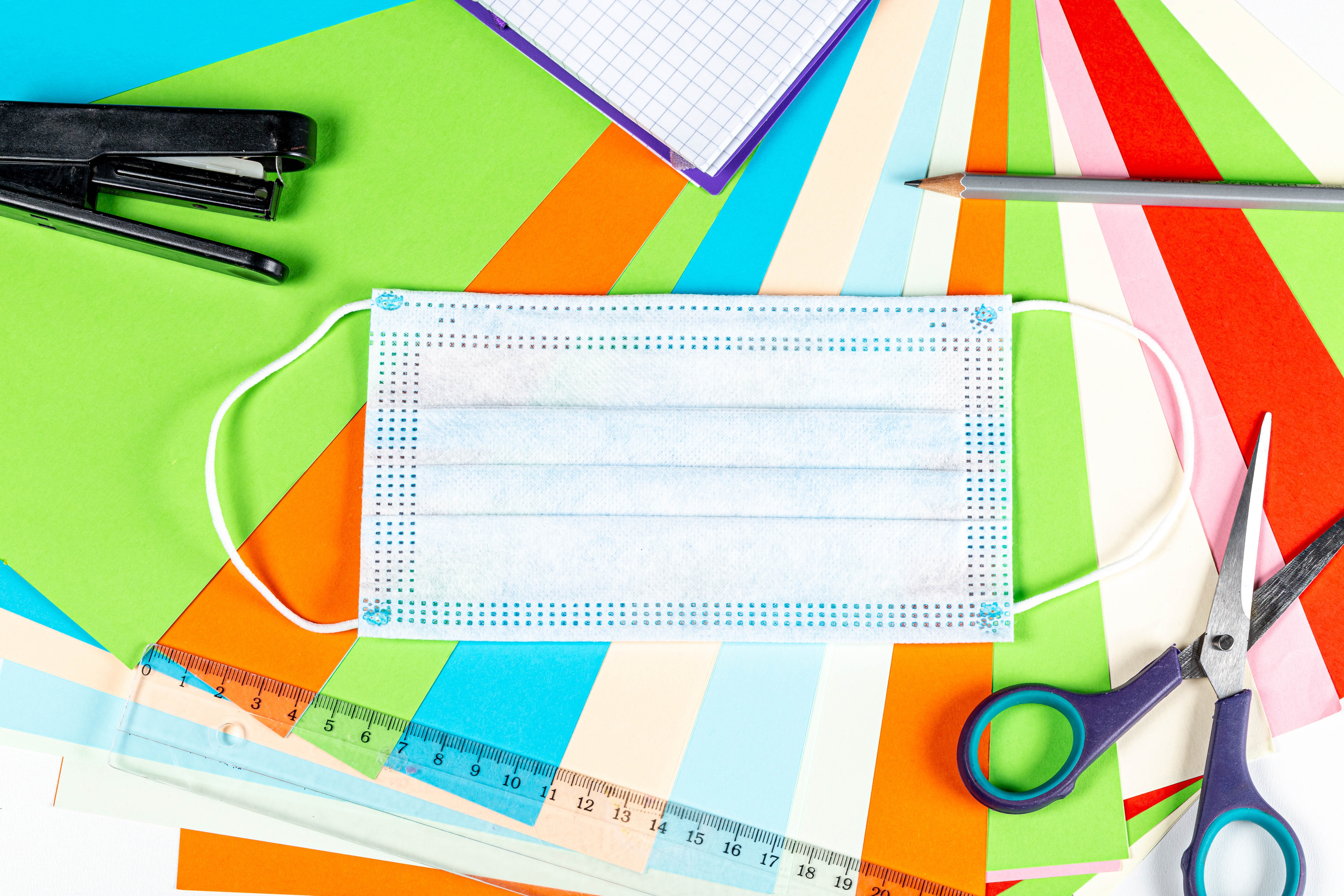 Face mask and school supplies on colorful paper HD Wallpaper