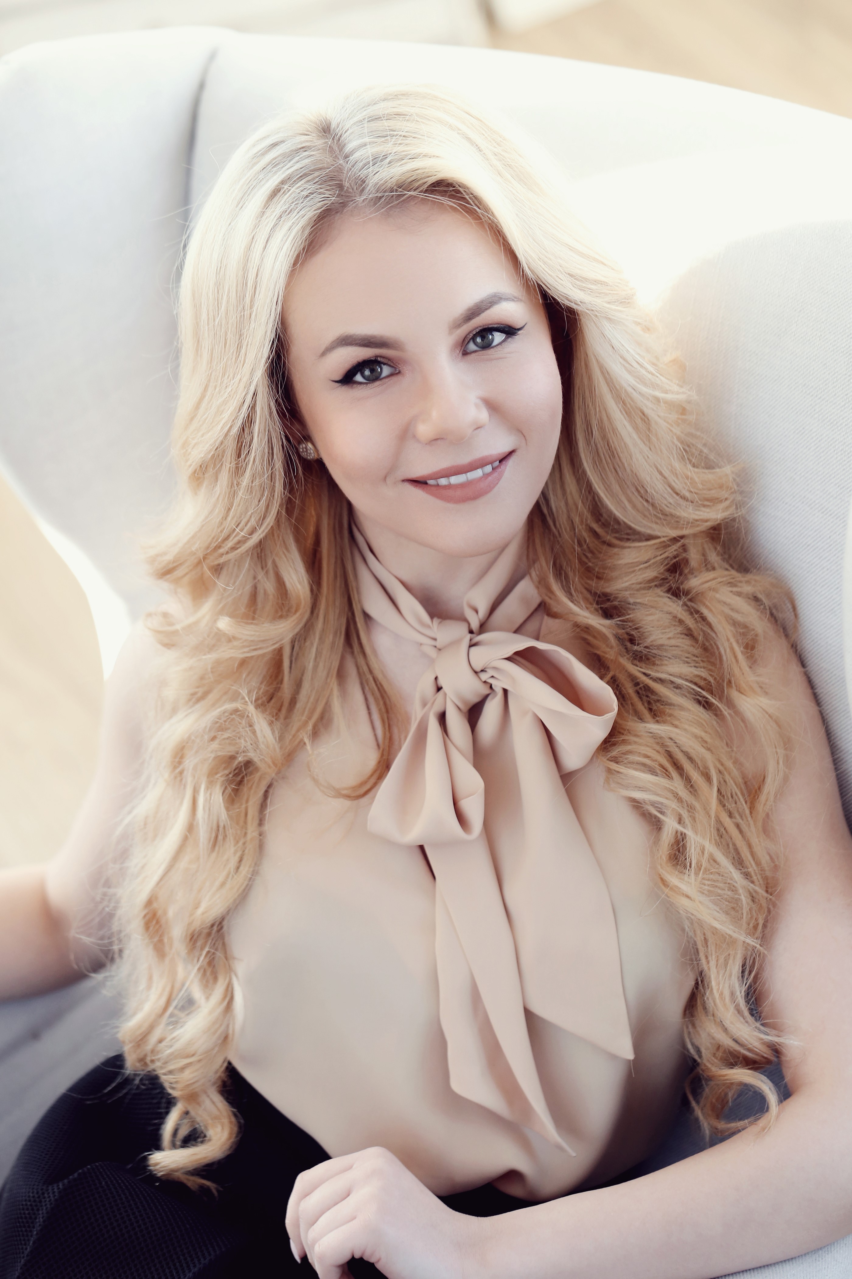 Blonde woman with bow blouse sitting in chair HD Phone Wallpaper