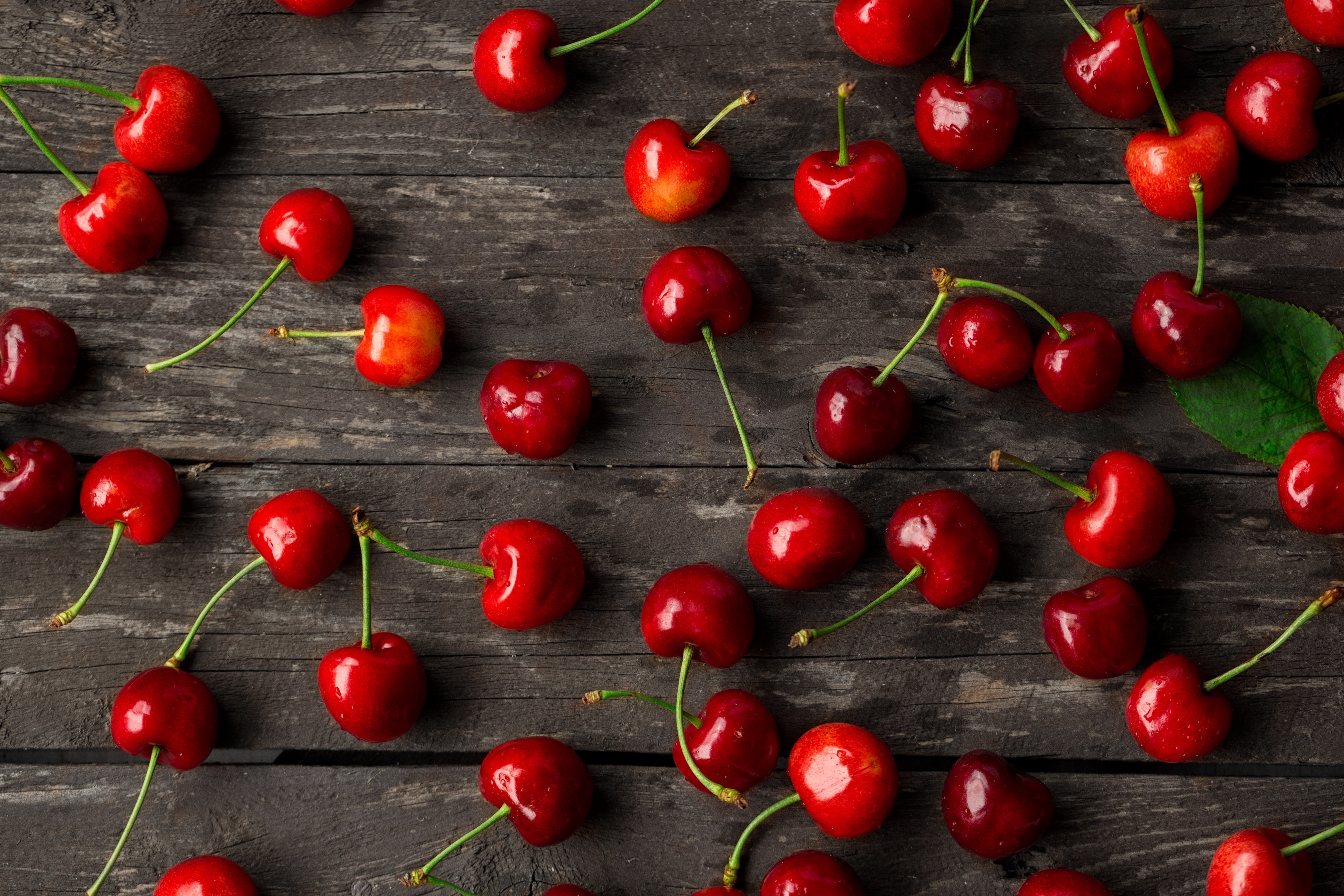 Many Cherries on a Dark Wooden Surface HD Wallpaper