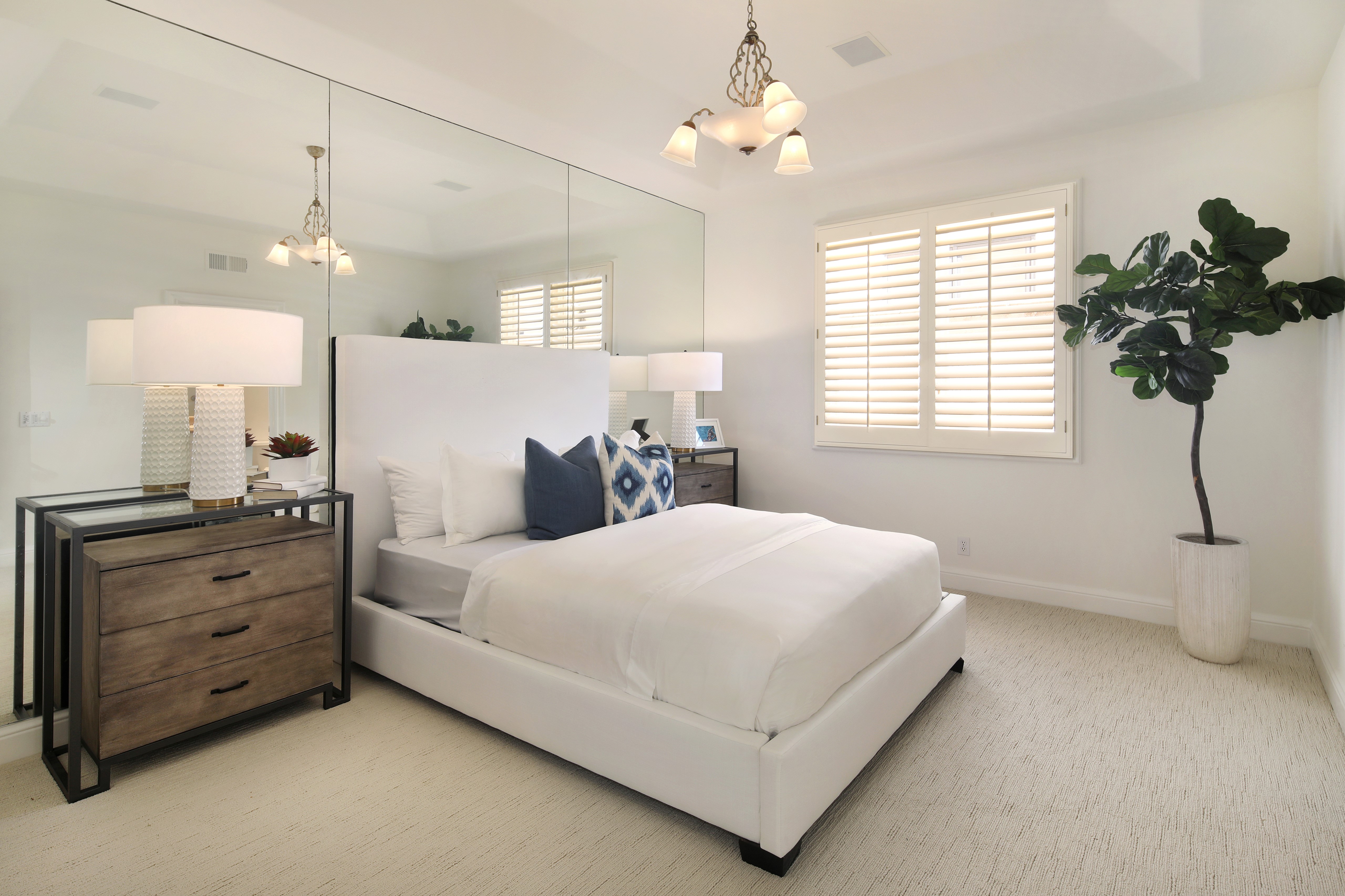 Bedroom with white bed, lamps, and mirrored wall HD Wallpaper