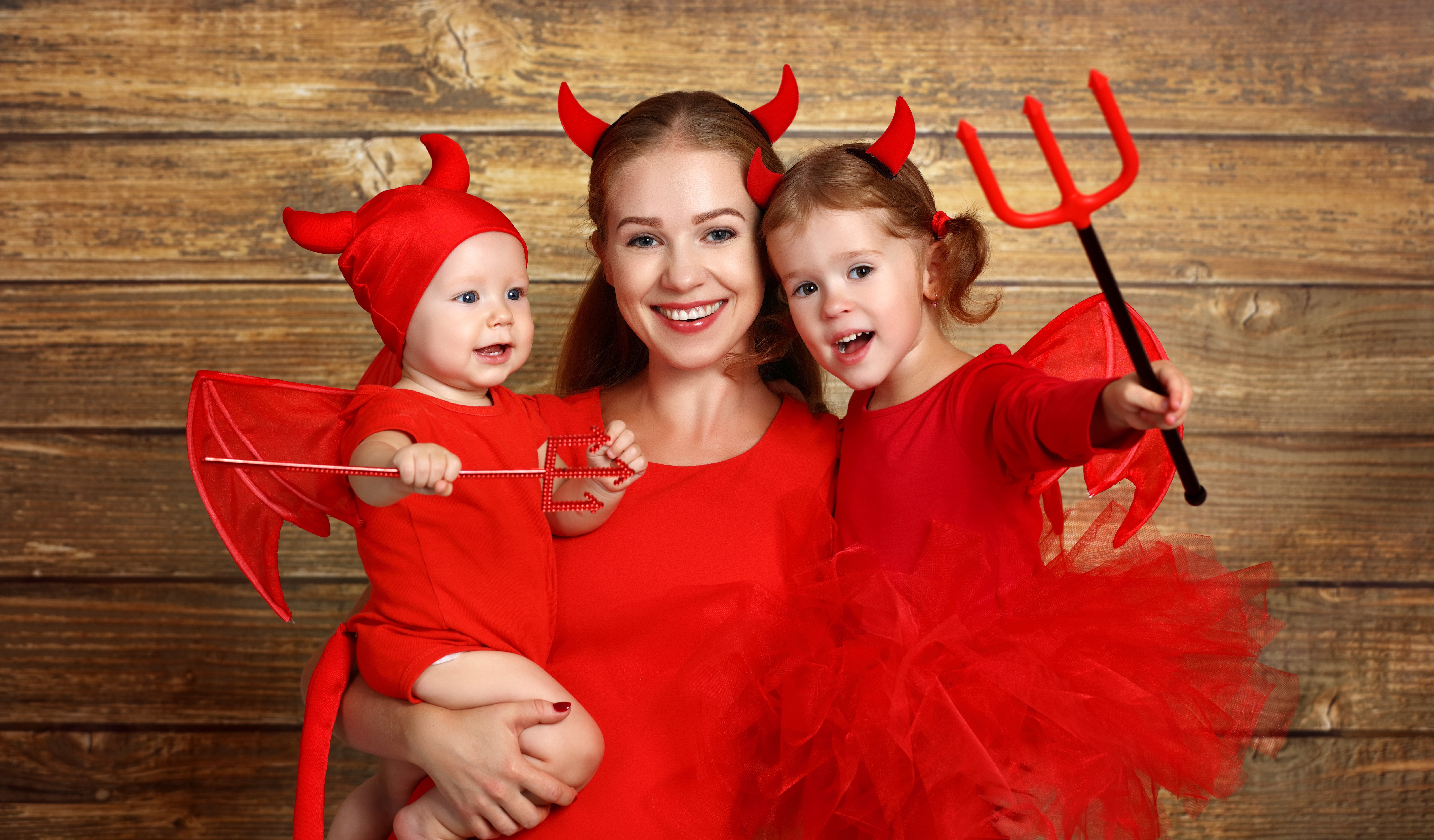 Mother and two children in devil costumes HD Wallpaper