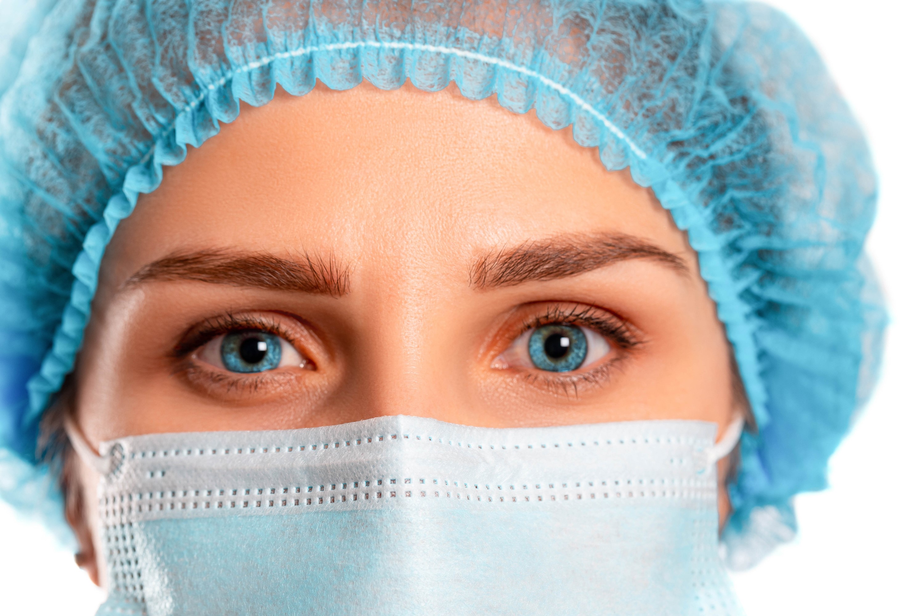 Close-up of a person wearing a surgical mask and cap HD Wallpaper