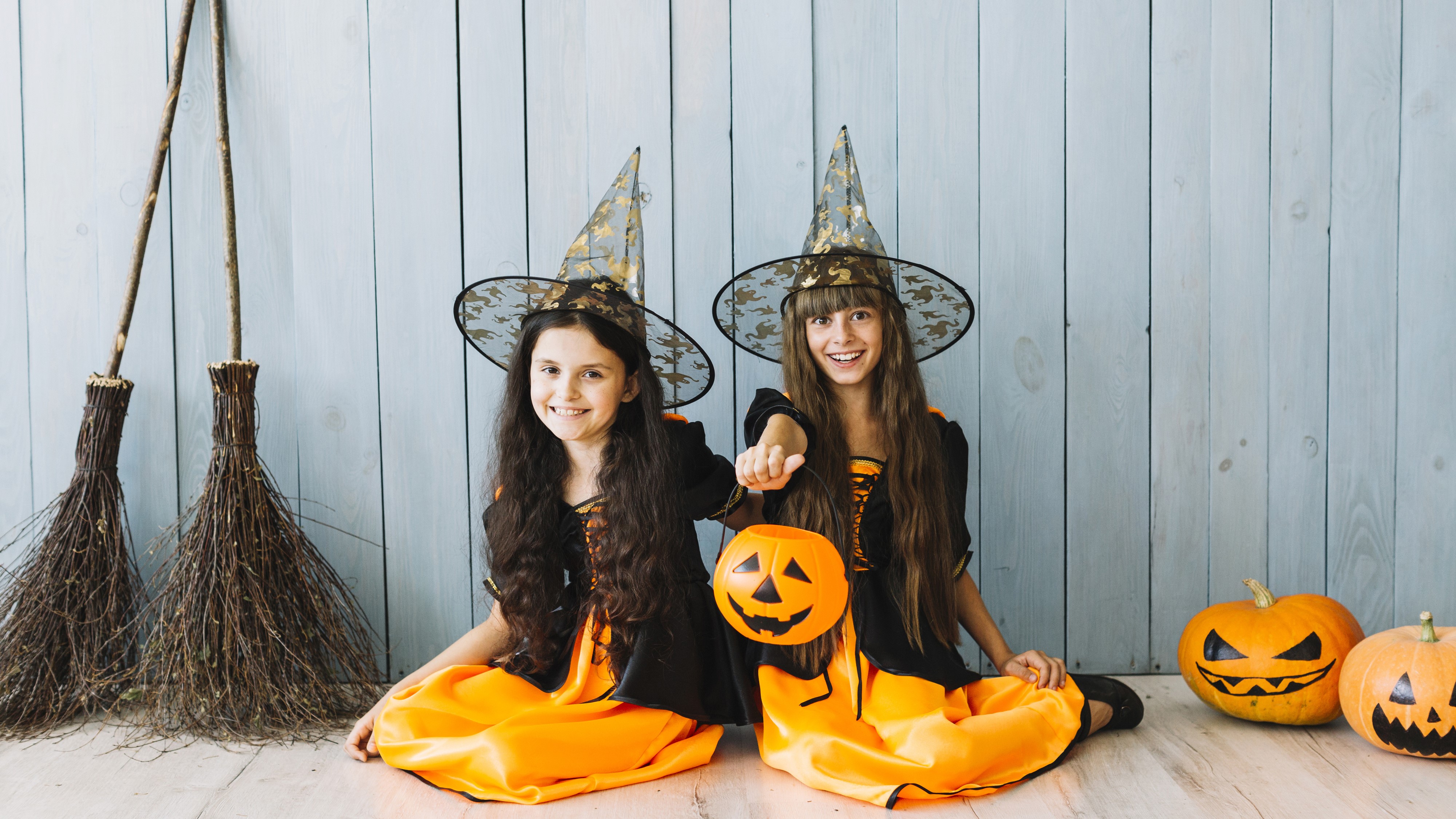 Two little girls in Halloween costumes with pumpkins HD Wallpaper