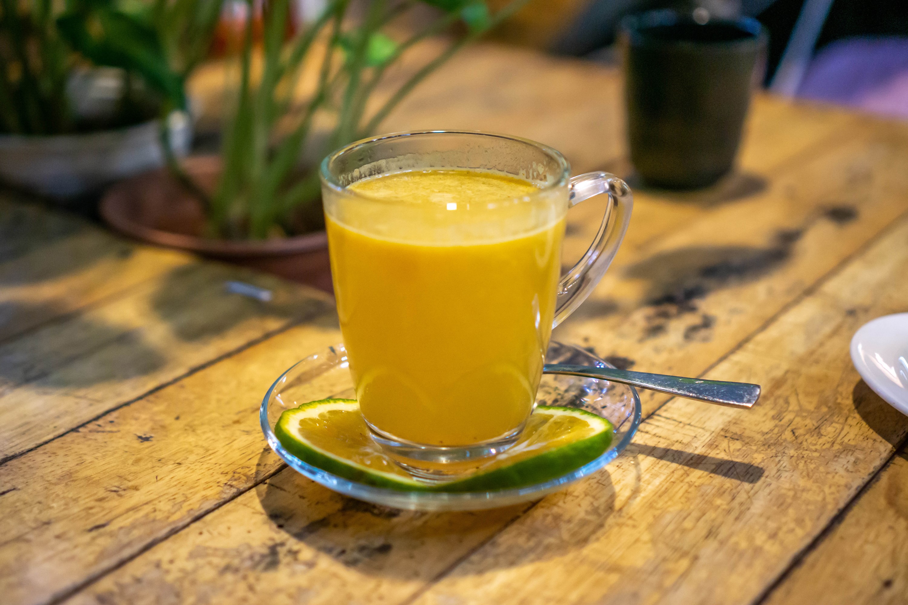 Glass mug of orange juice with lime on a wooden table HD Wallpaper