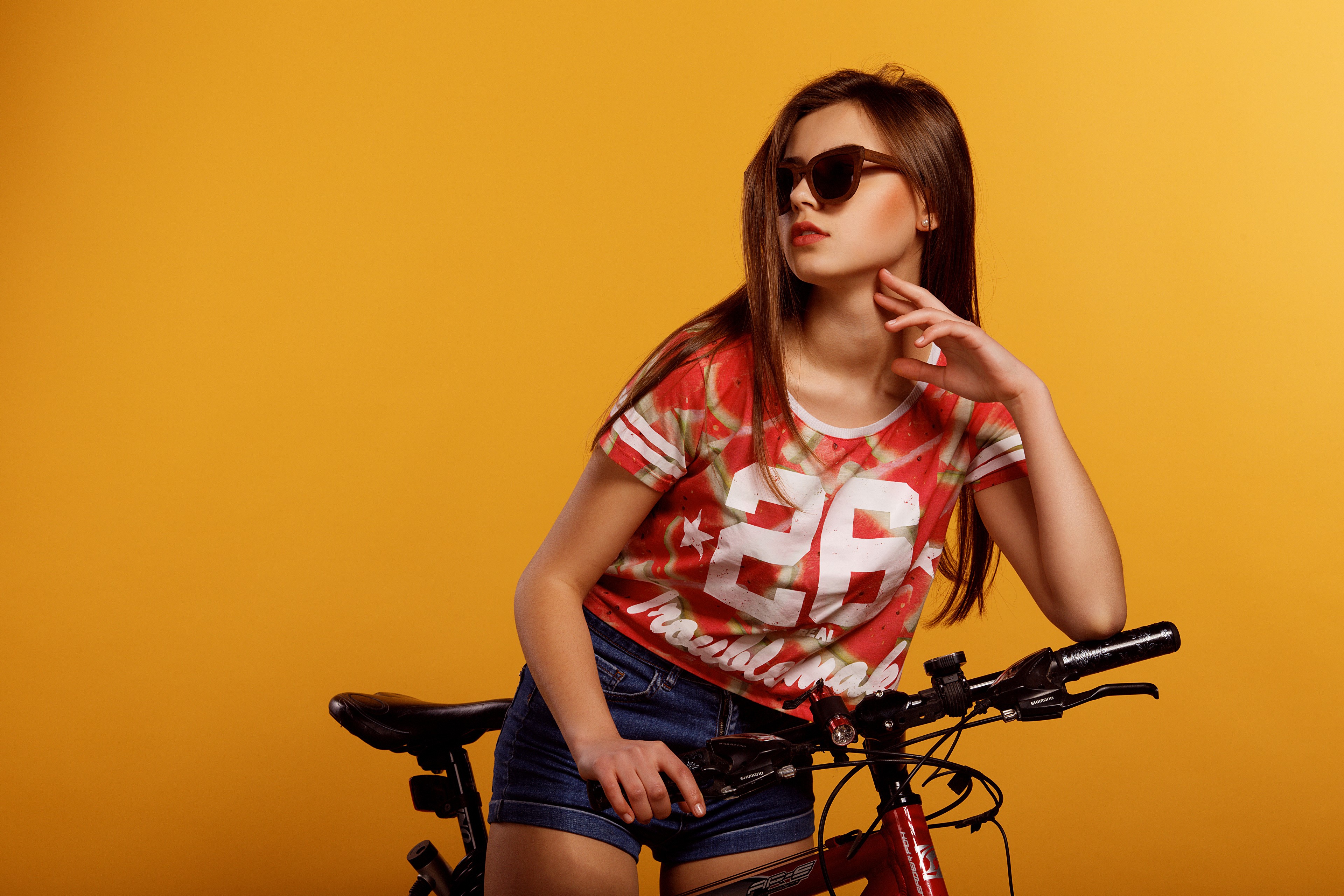 Girl with sunglasses and bicycle on colored background HD Wallpaper