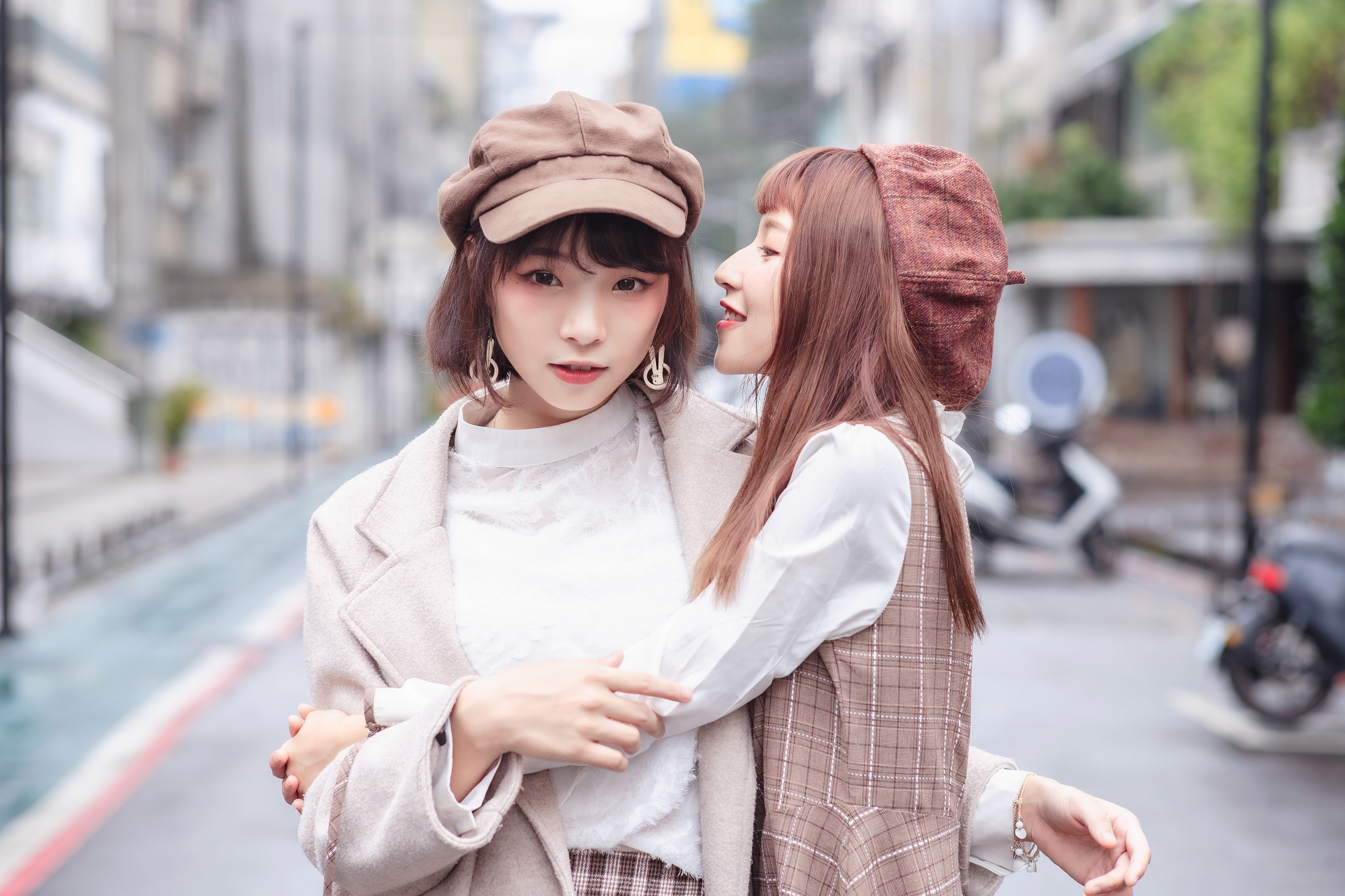 Two Asian women wearing caps and coats HD Wallpaper