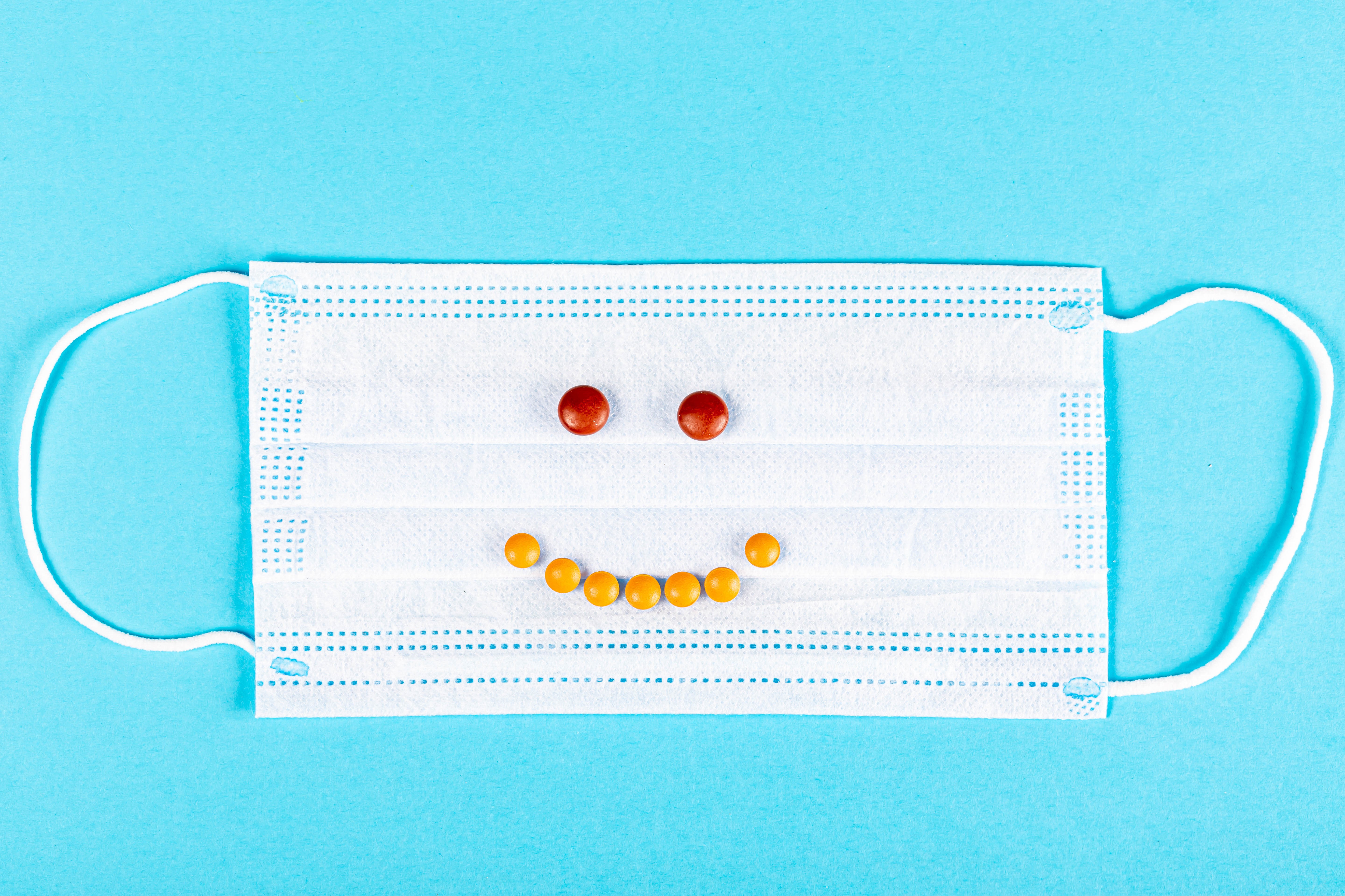 Face mask with pills forming a smiley face HD Wallpaper
