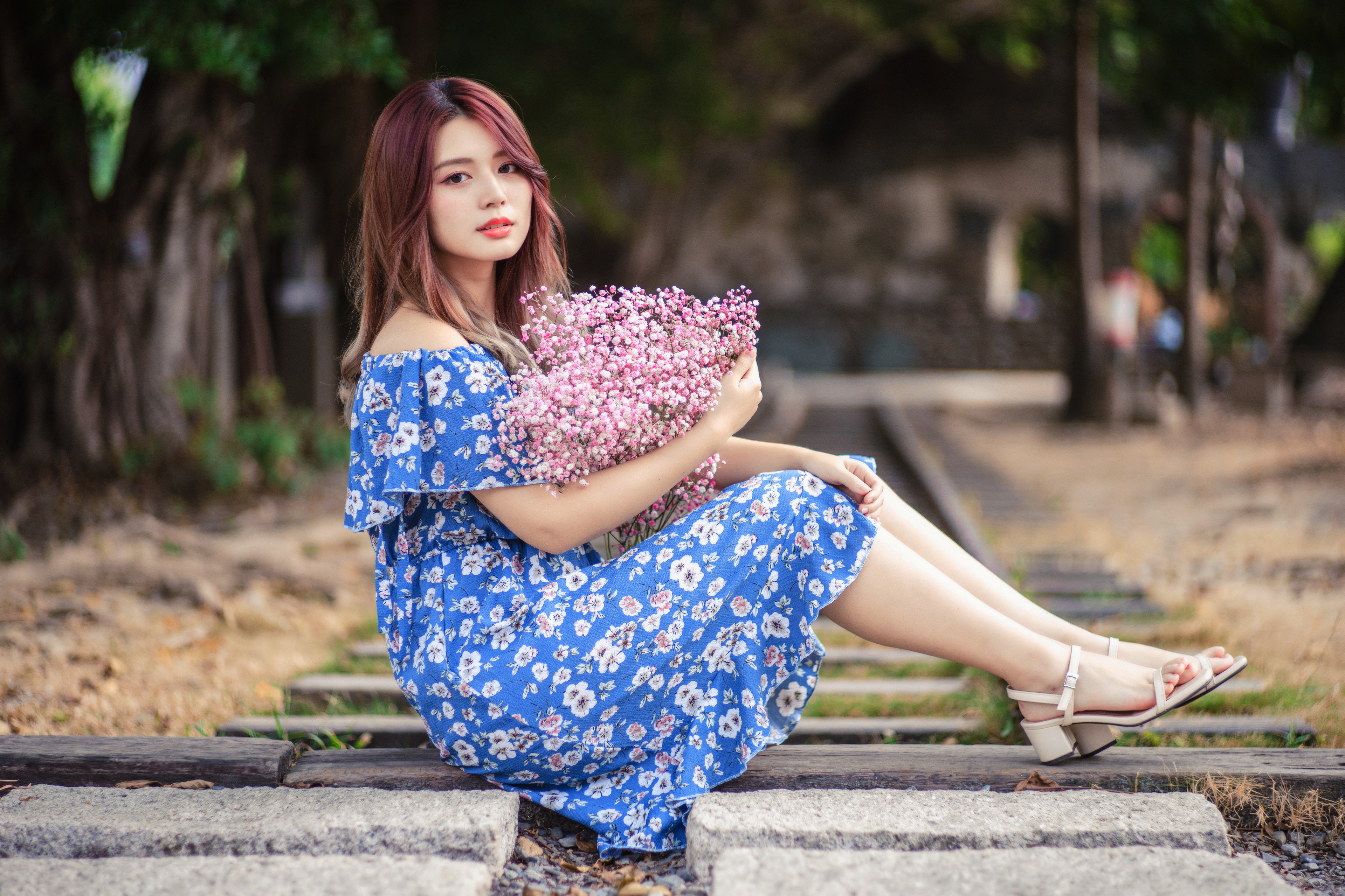 Asian woman in blue dress holding pink flowers HD Wallpaper