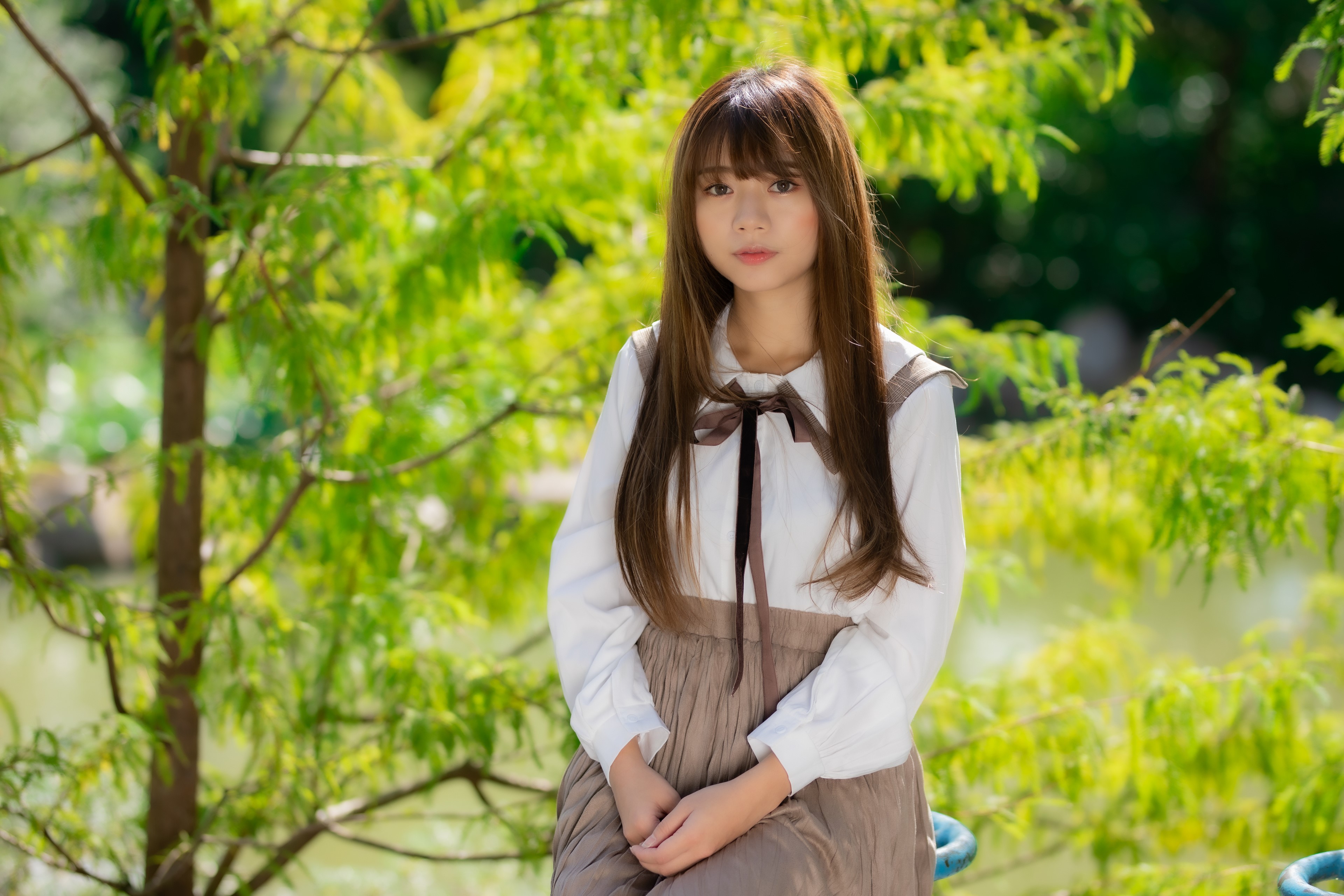 Asian girl sitting in a park HD Wallpaper