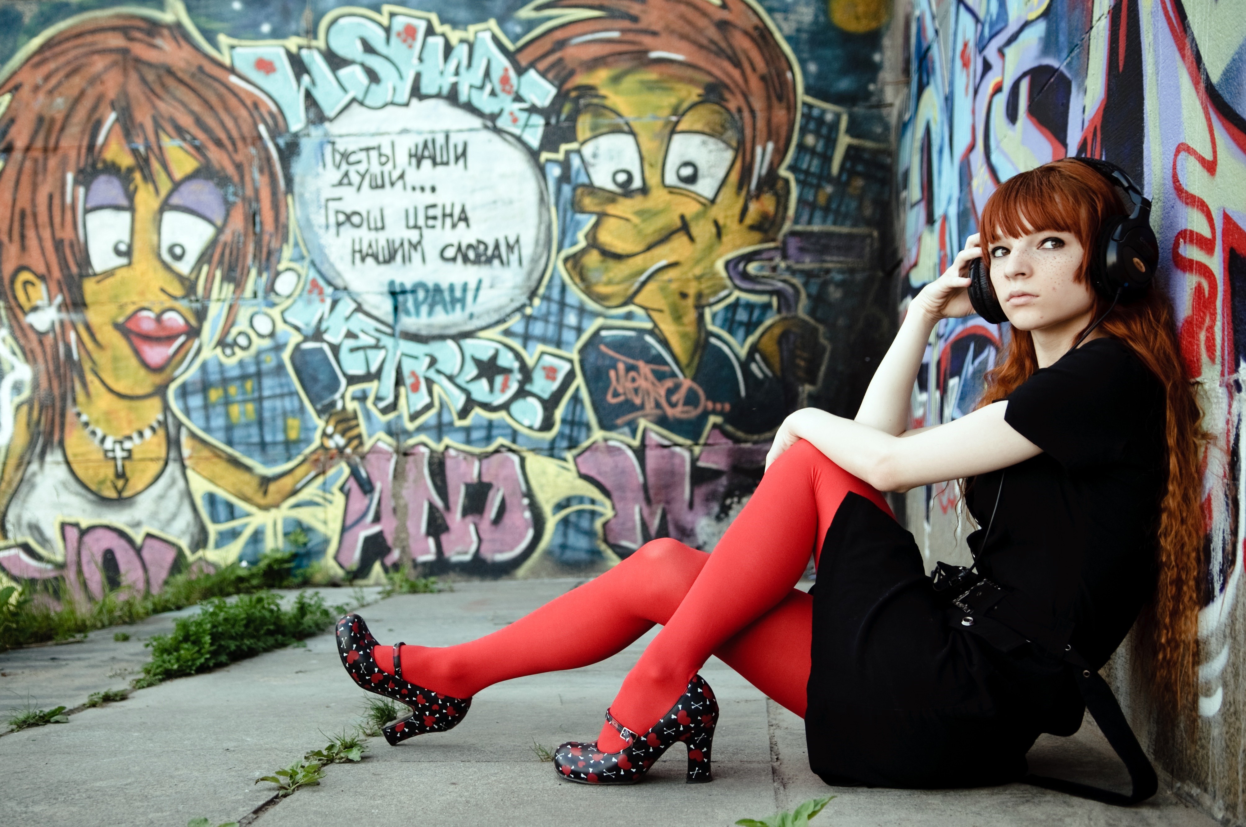 Redhead girl with headphones sitting by graffiti wall HD Wallpaper