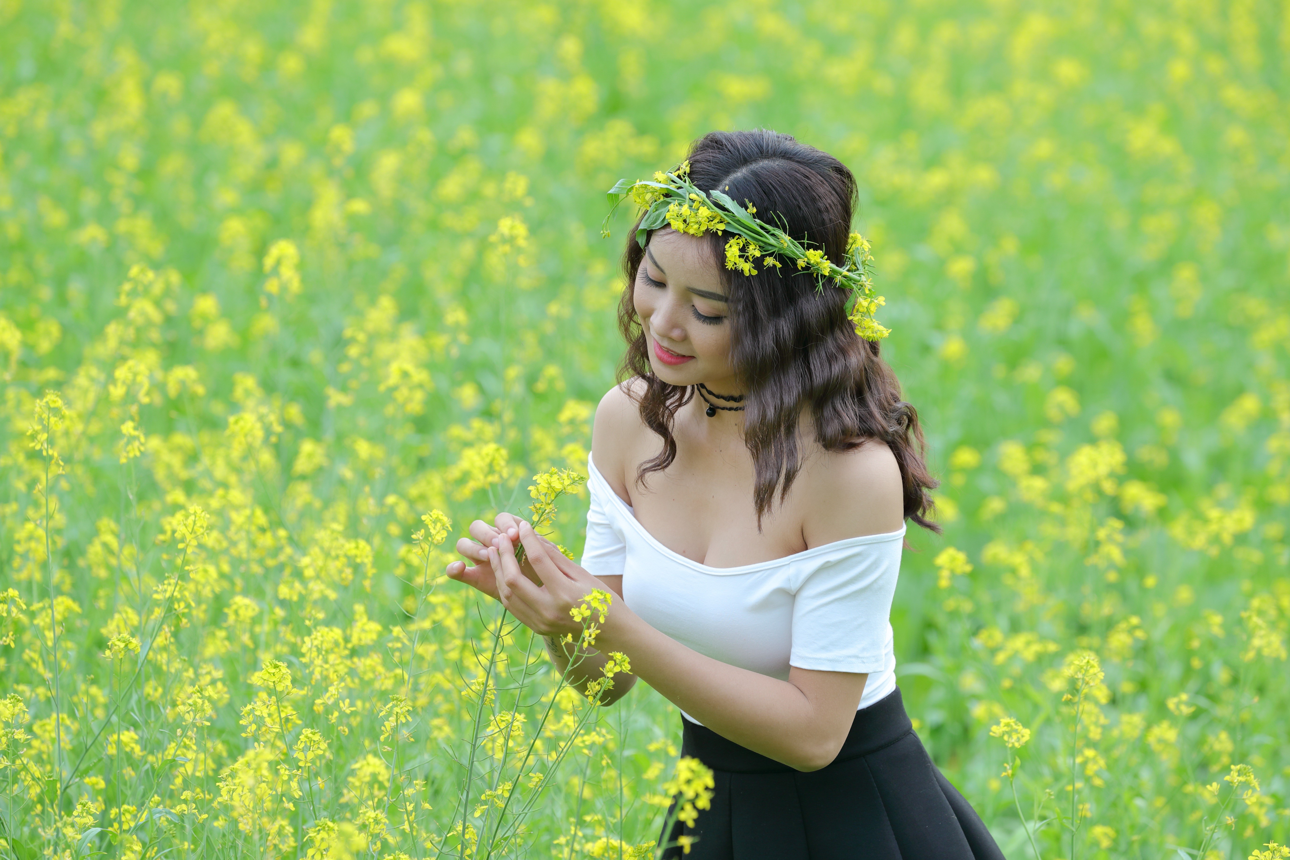 Asian woman with flower wreath in rapeseed field HD Wallpaper