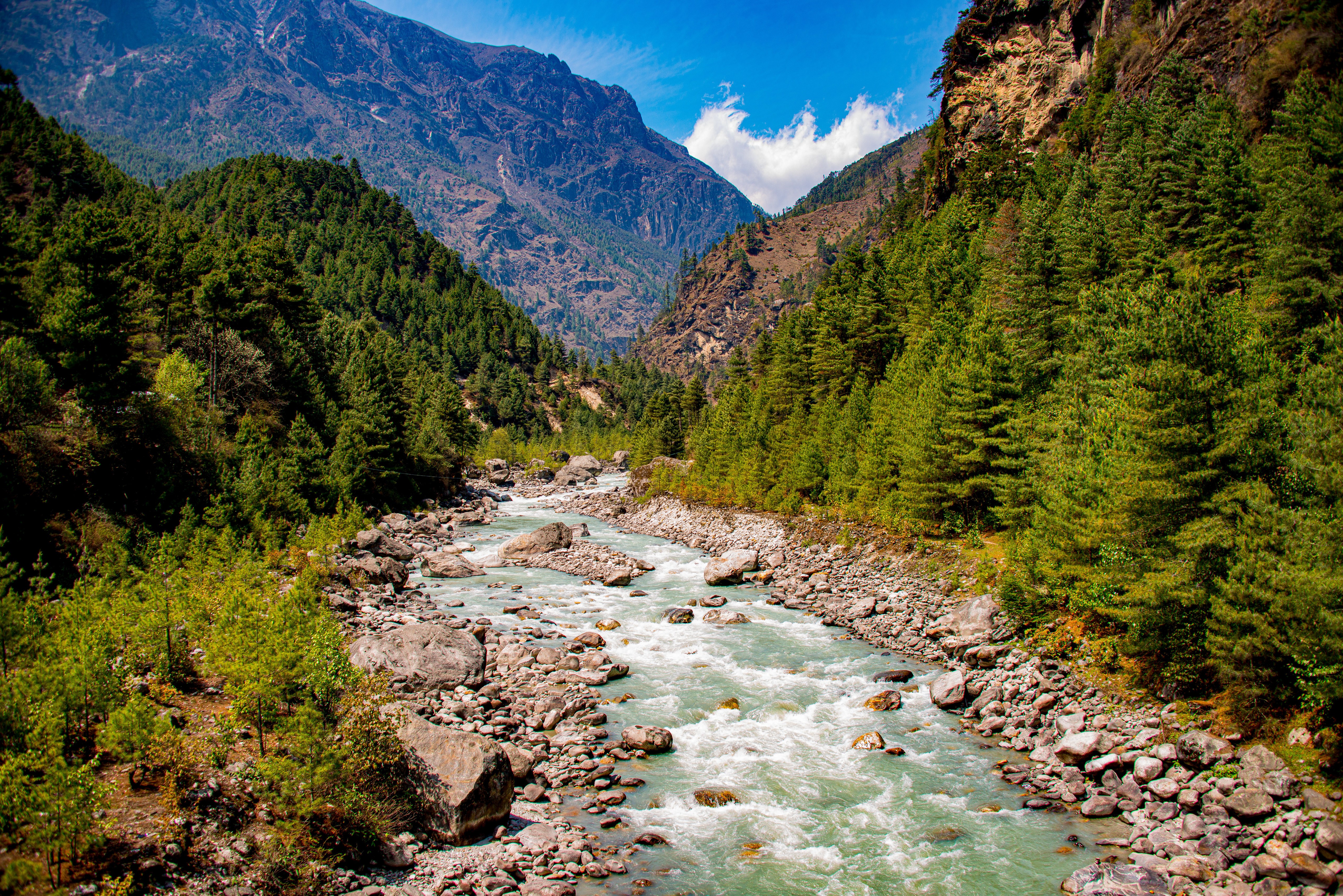 River flowing through a valley in Nepal with mountains and trees HD Wallpaper