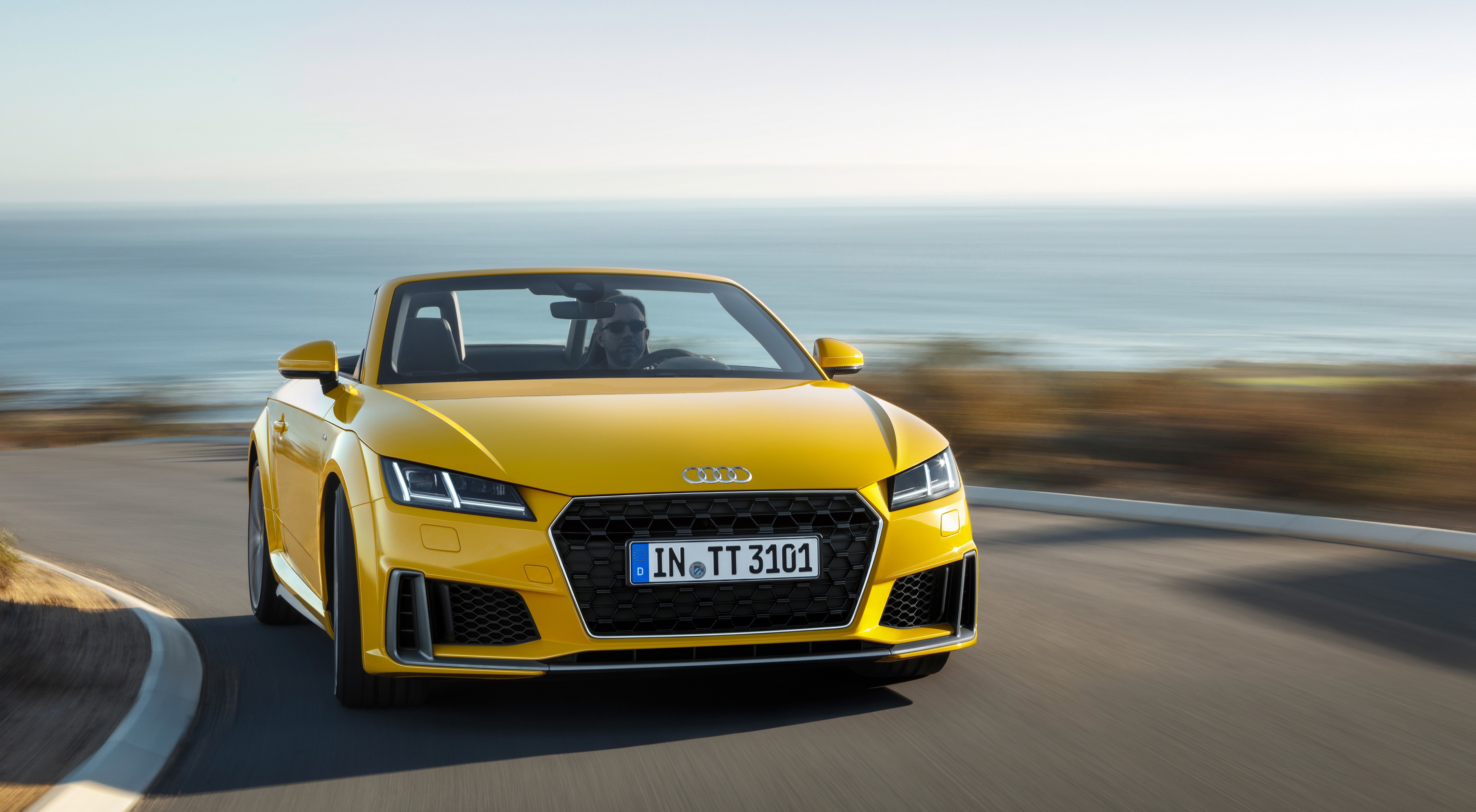 Yellow Audi TT Roadster driving on a coastal road HD Wallpaper