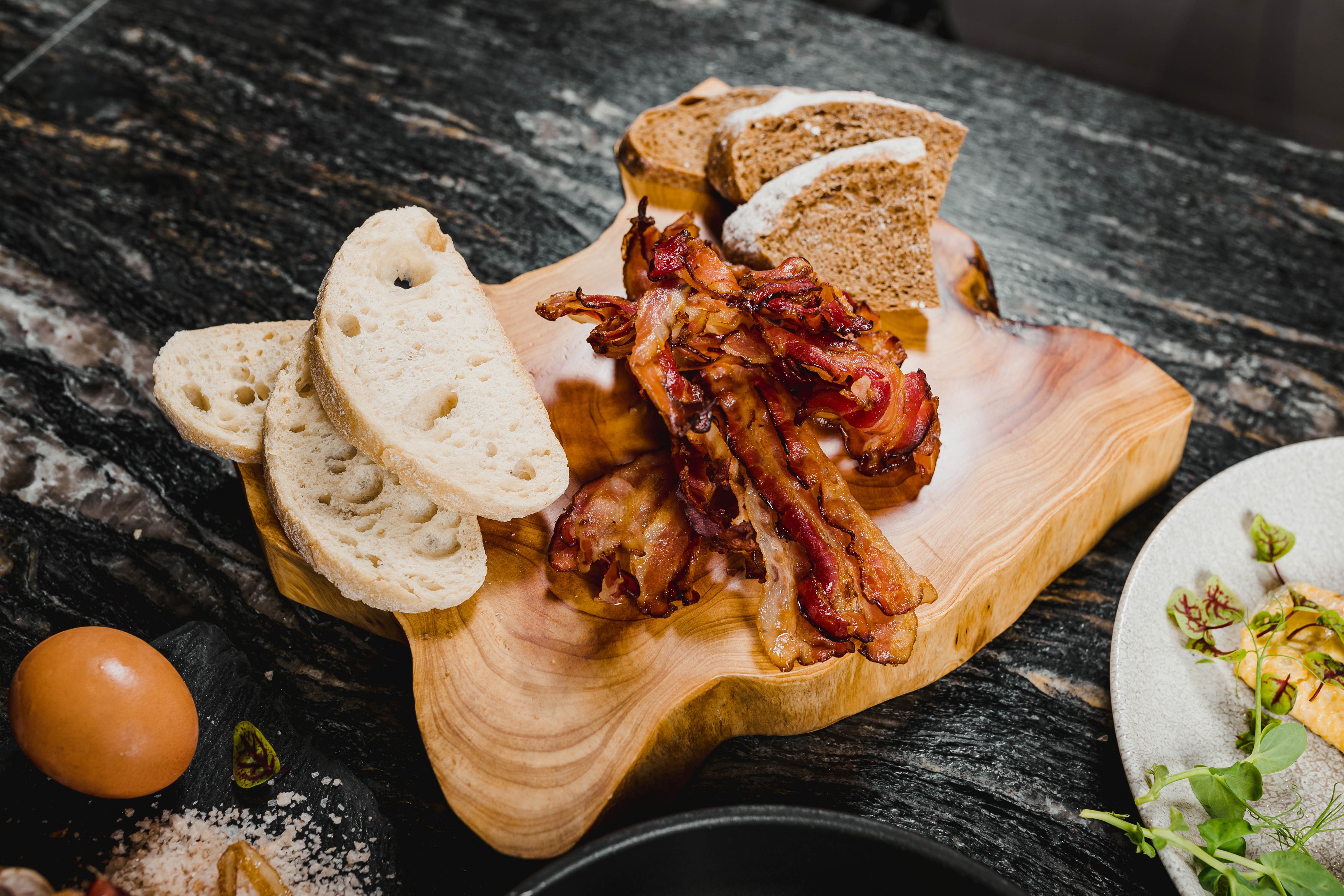 Bacon and bread on a wooden cutting board with egg HD Wallpaper