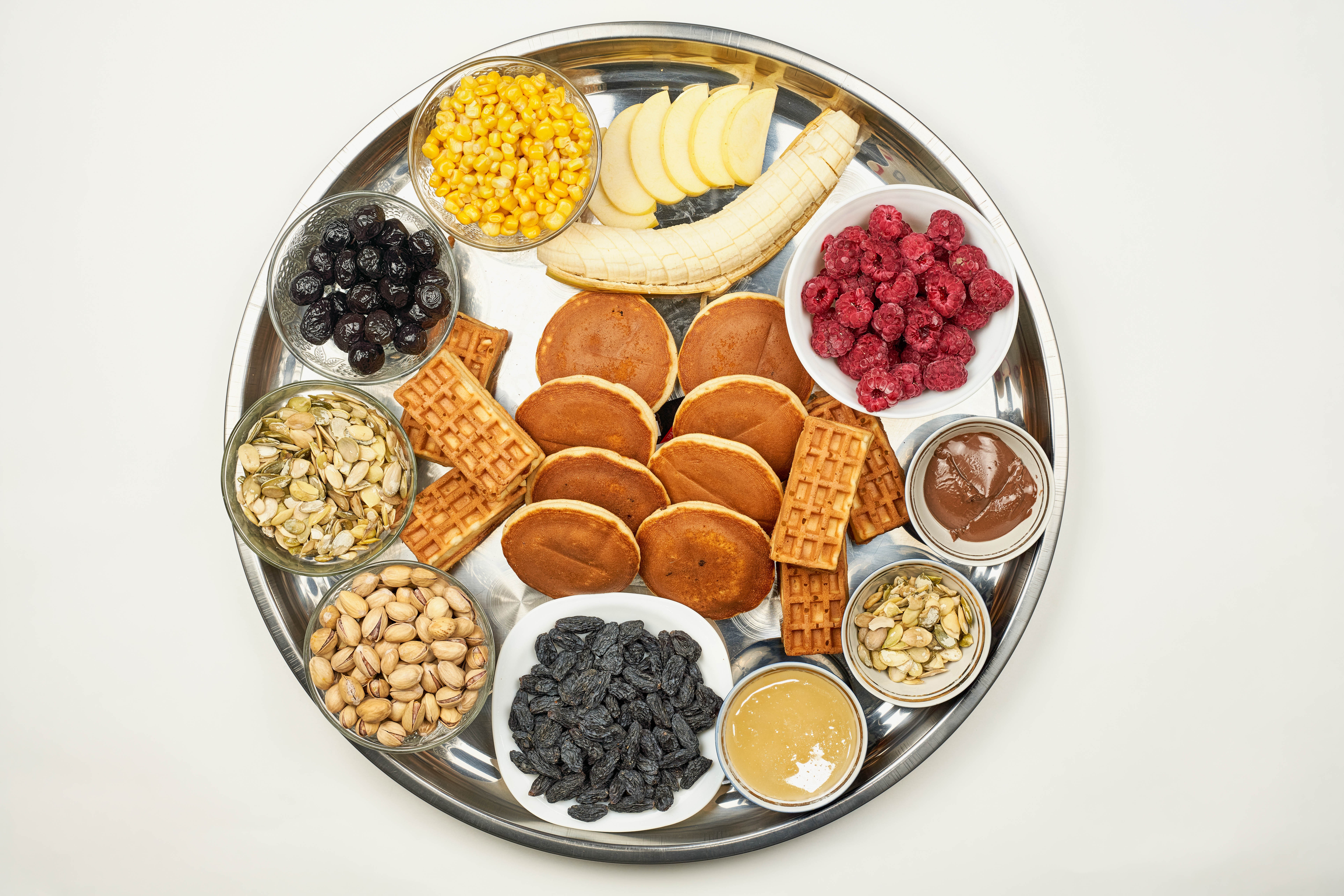 Breakfast platter with fruits, nuts, waffles, and pancakes HD Wallpaper