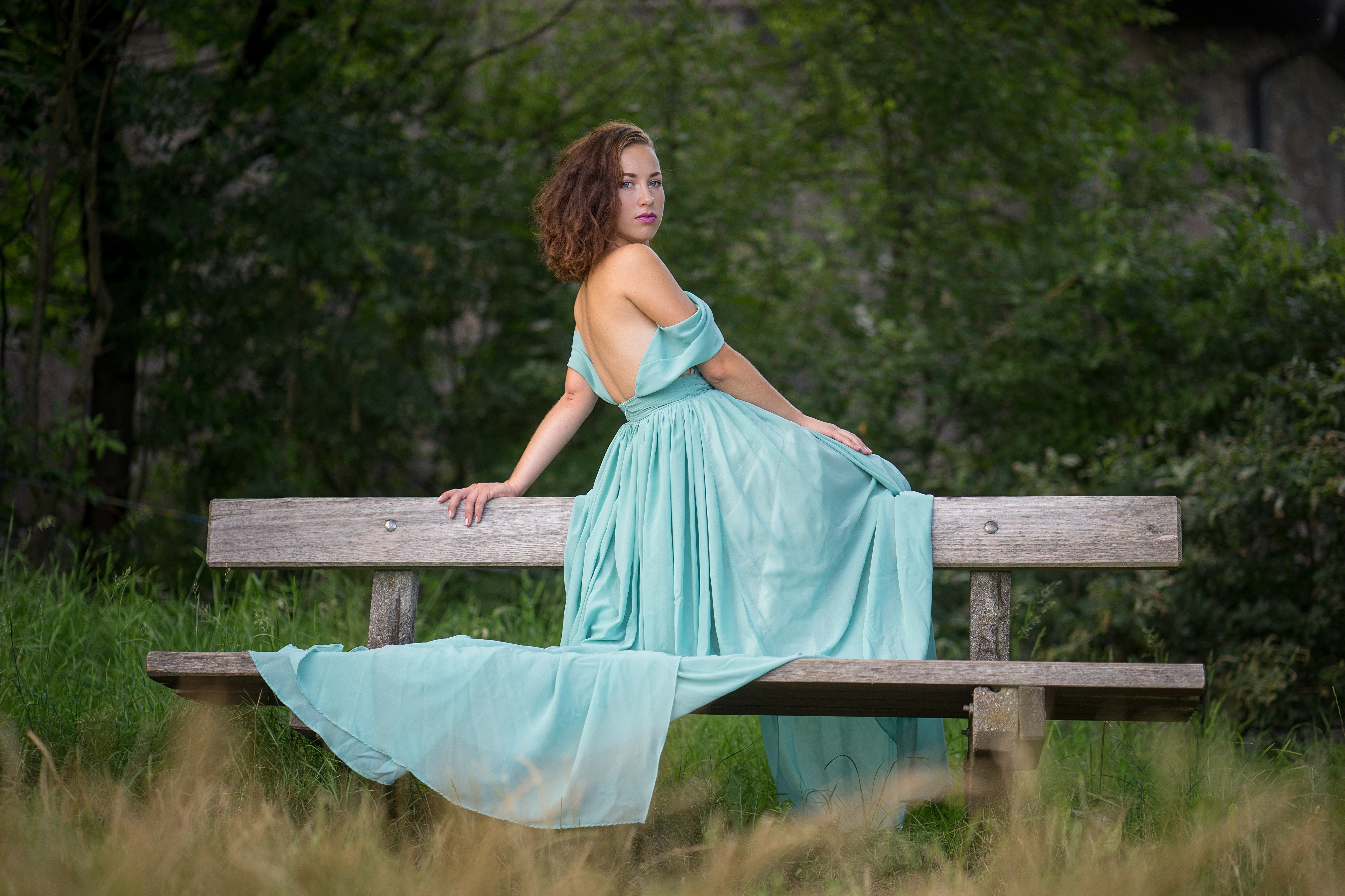 Woman in a light blue dress sitting on a bench HD Wallpaper