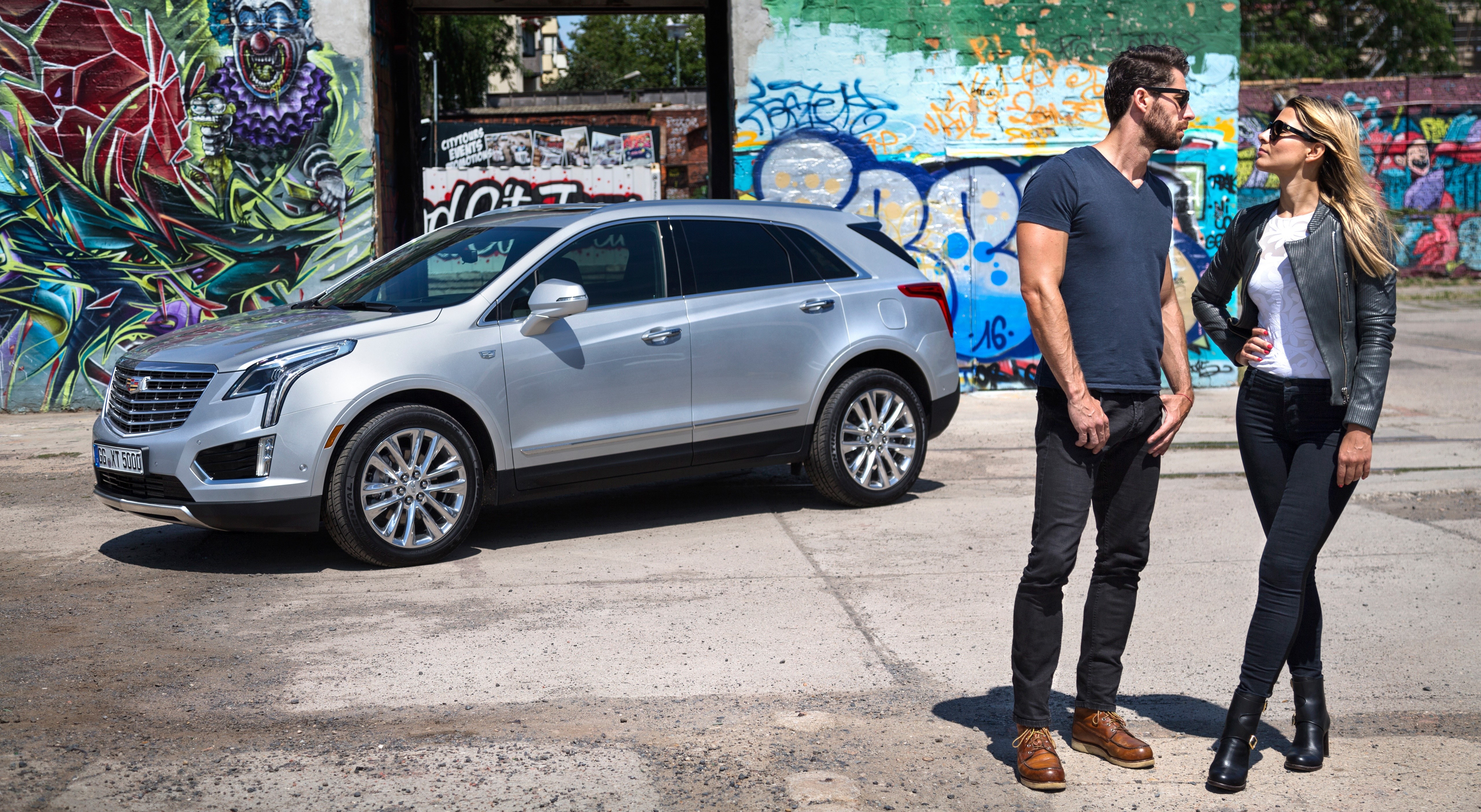 Cadillac XT5 Crossover with Couple in Front of Graffiti Wall HD Wallpaper