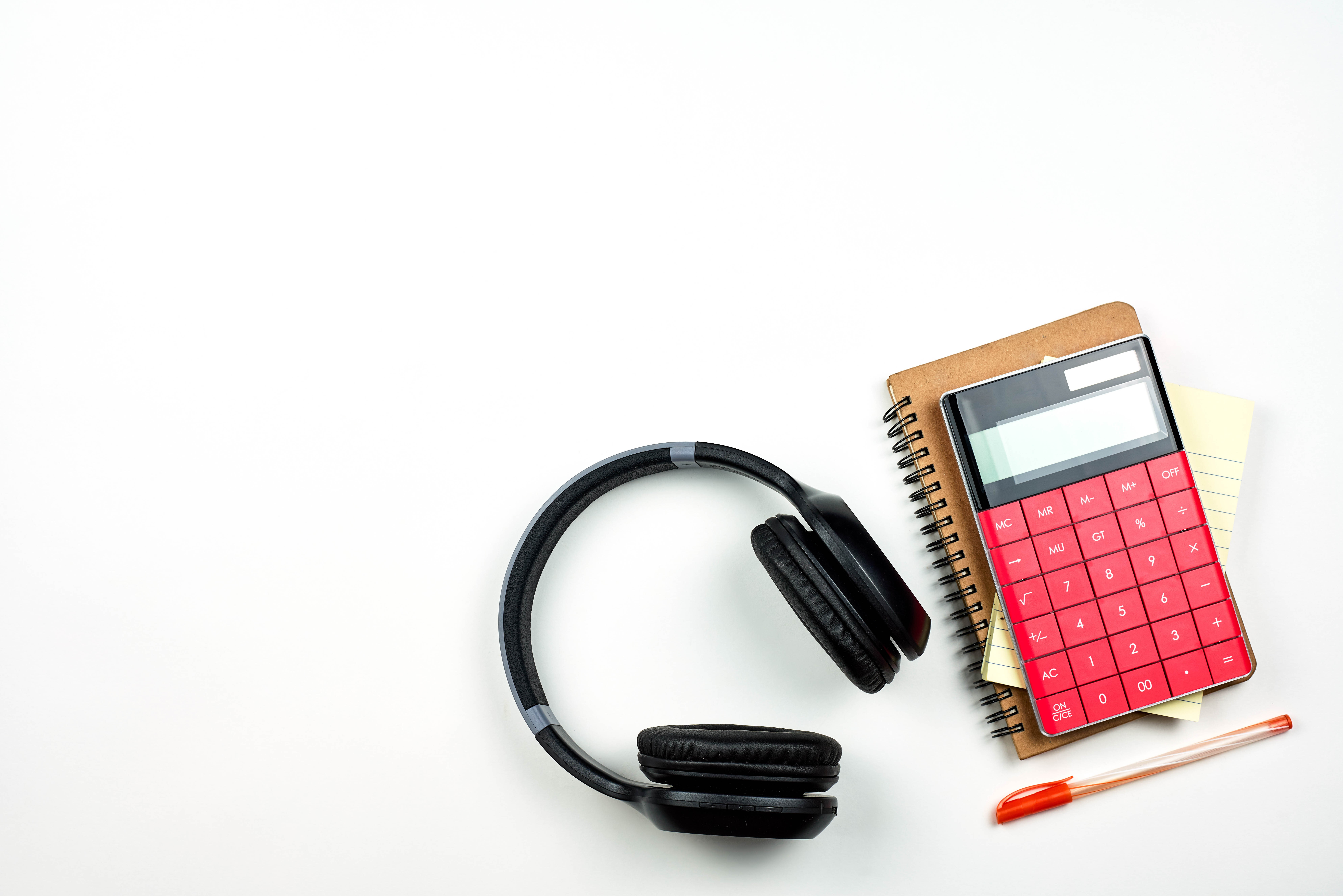 Headphones, calculator, notepad, and pen on white background HD Wallpaper