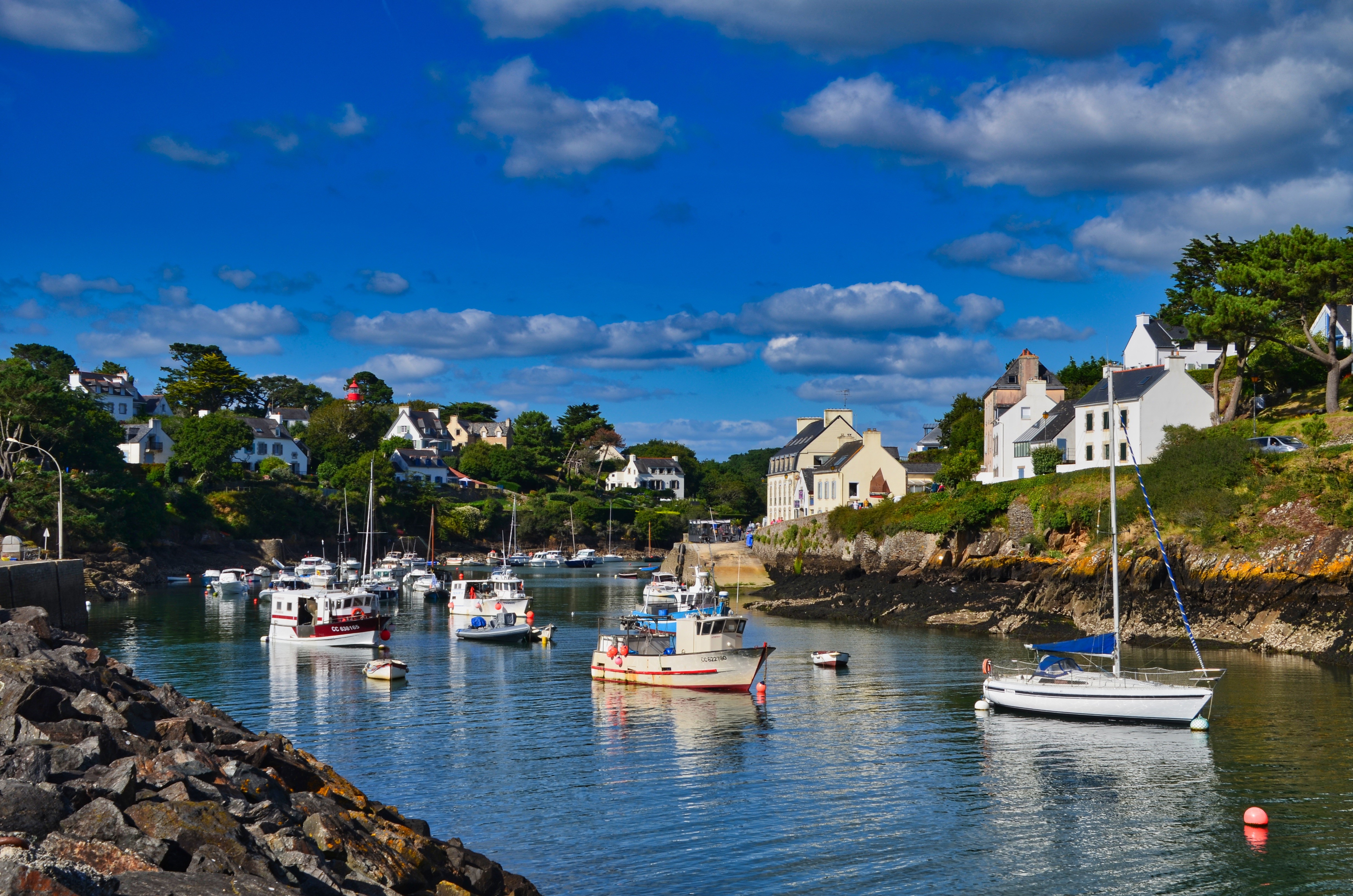 Boats in a harbor with houses in Brittany, France HD Wallpaper