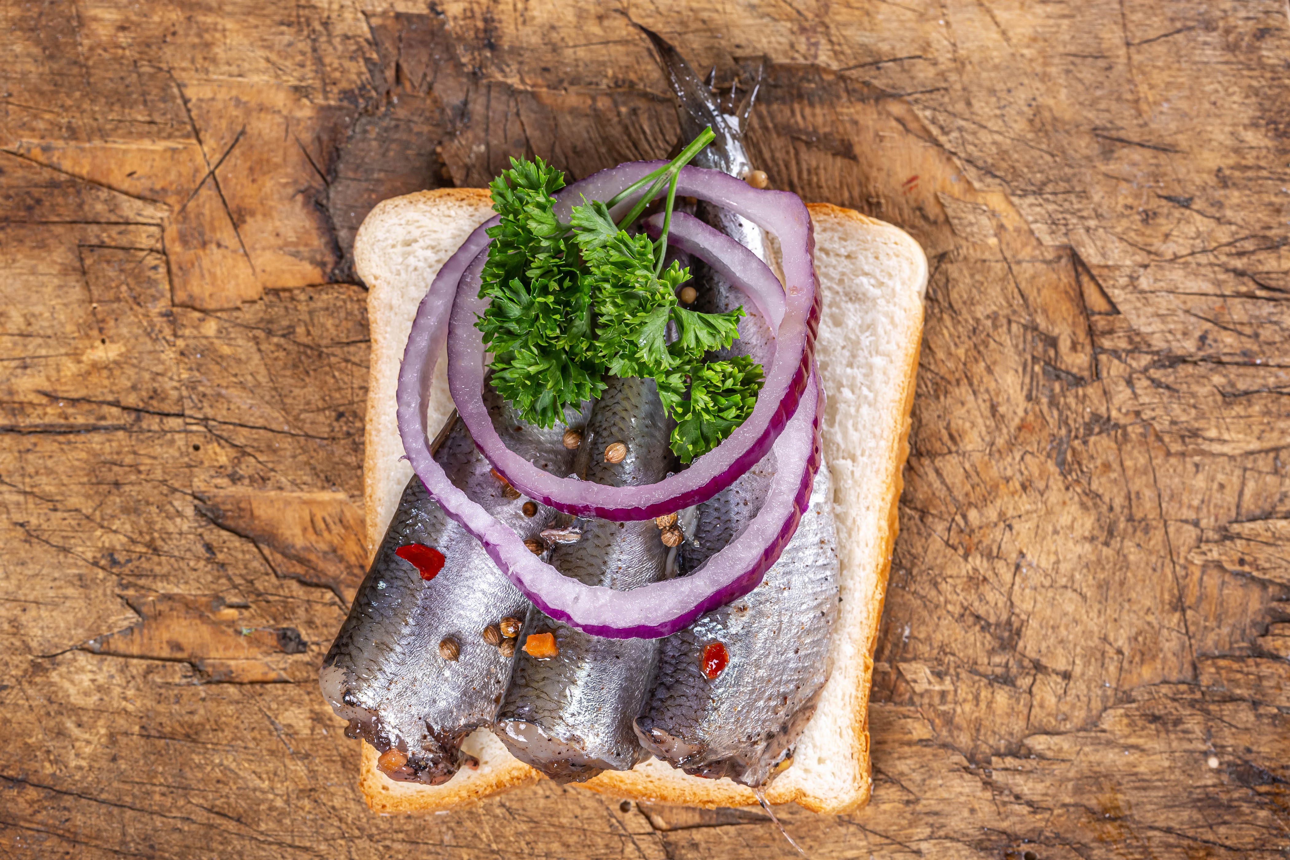 Sandwich with herring, onion, and parsley on bread HD Wallpaper