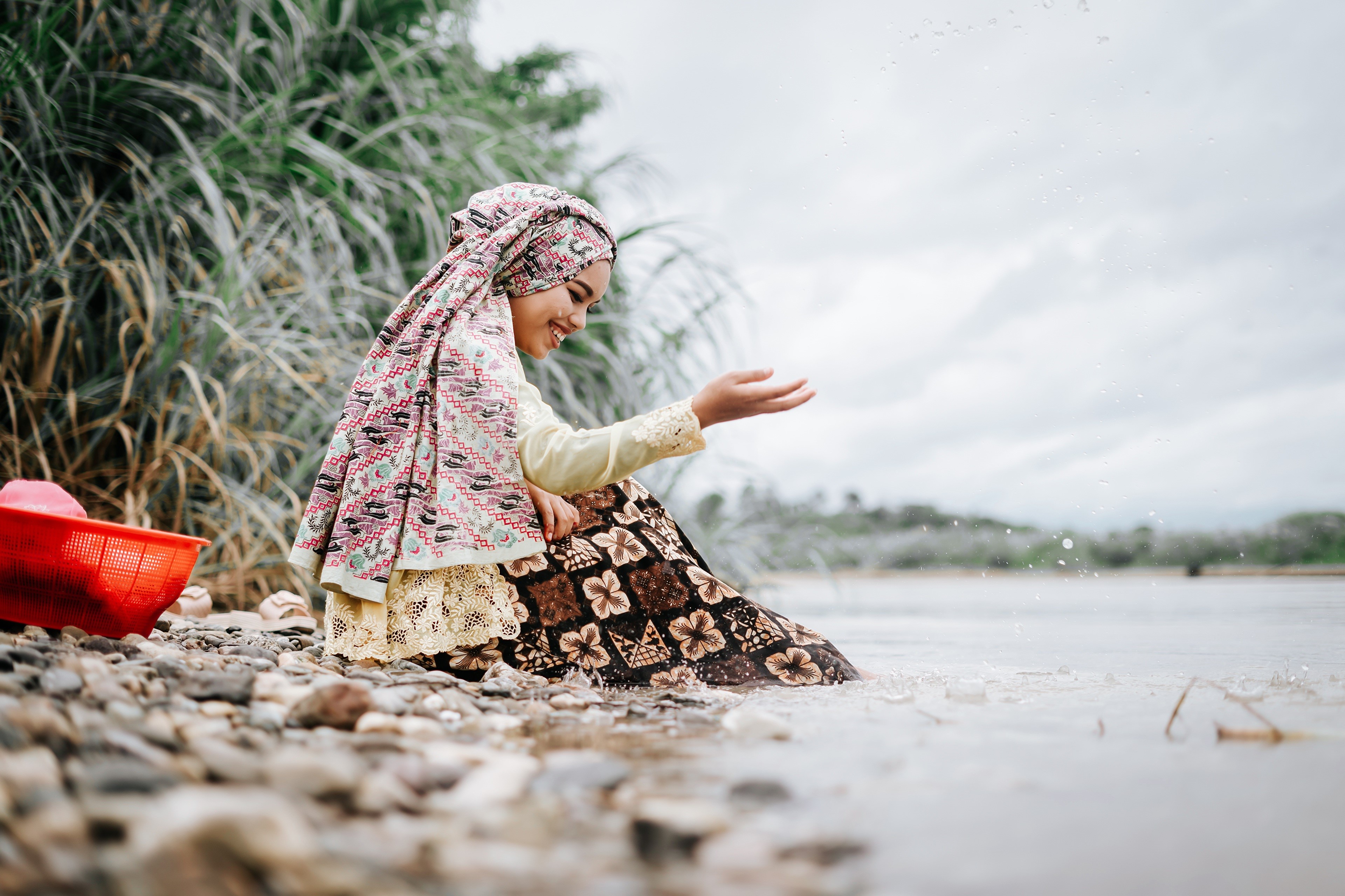 Indonesian woman in traditional clothing by the water HD Wallpaper