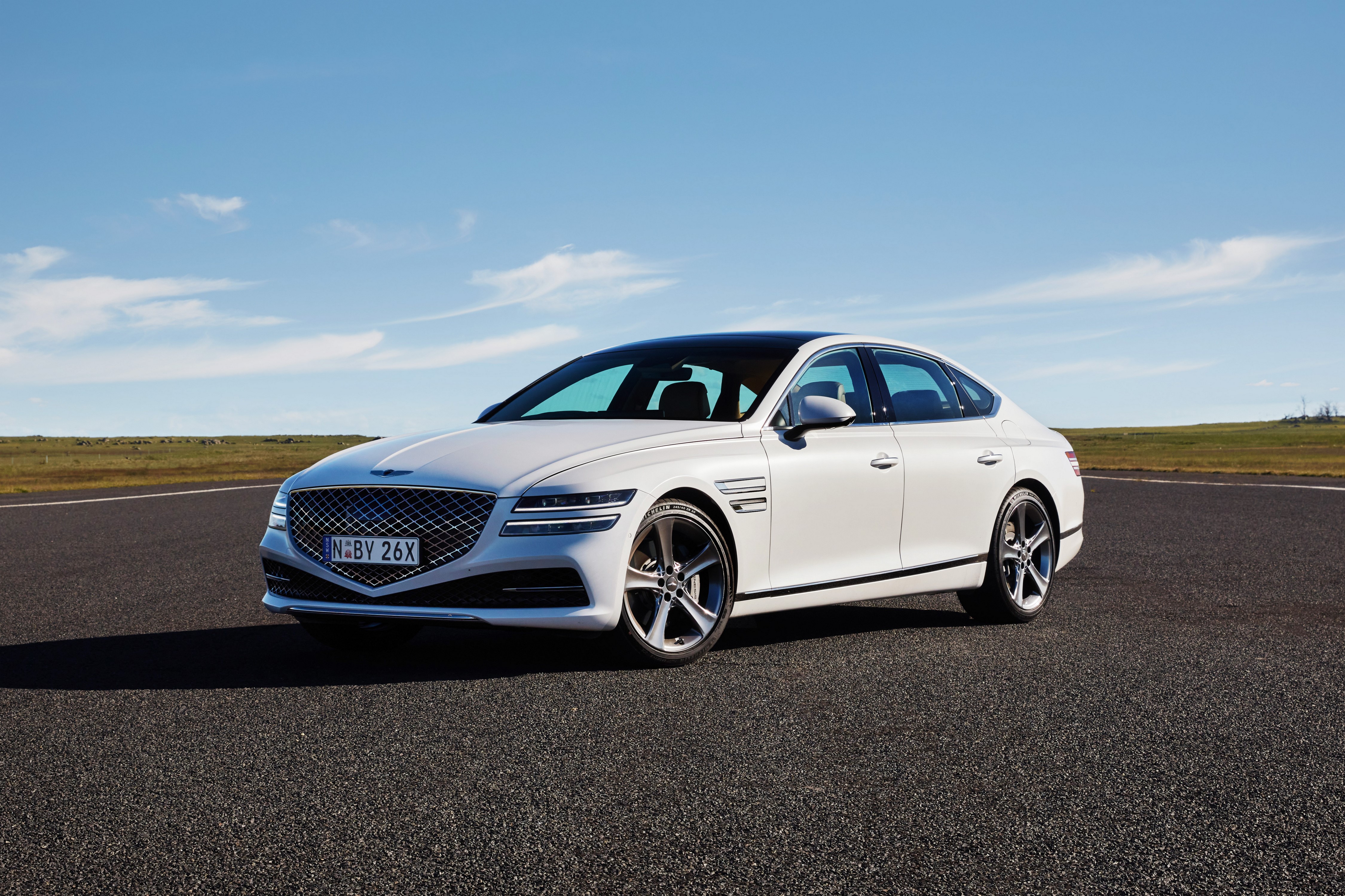 White Genesis G80 3.5T AWD sedan on a road HD Wallpaper