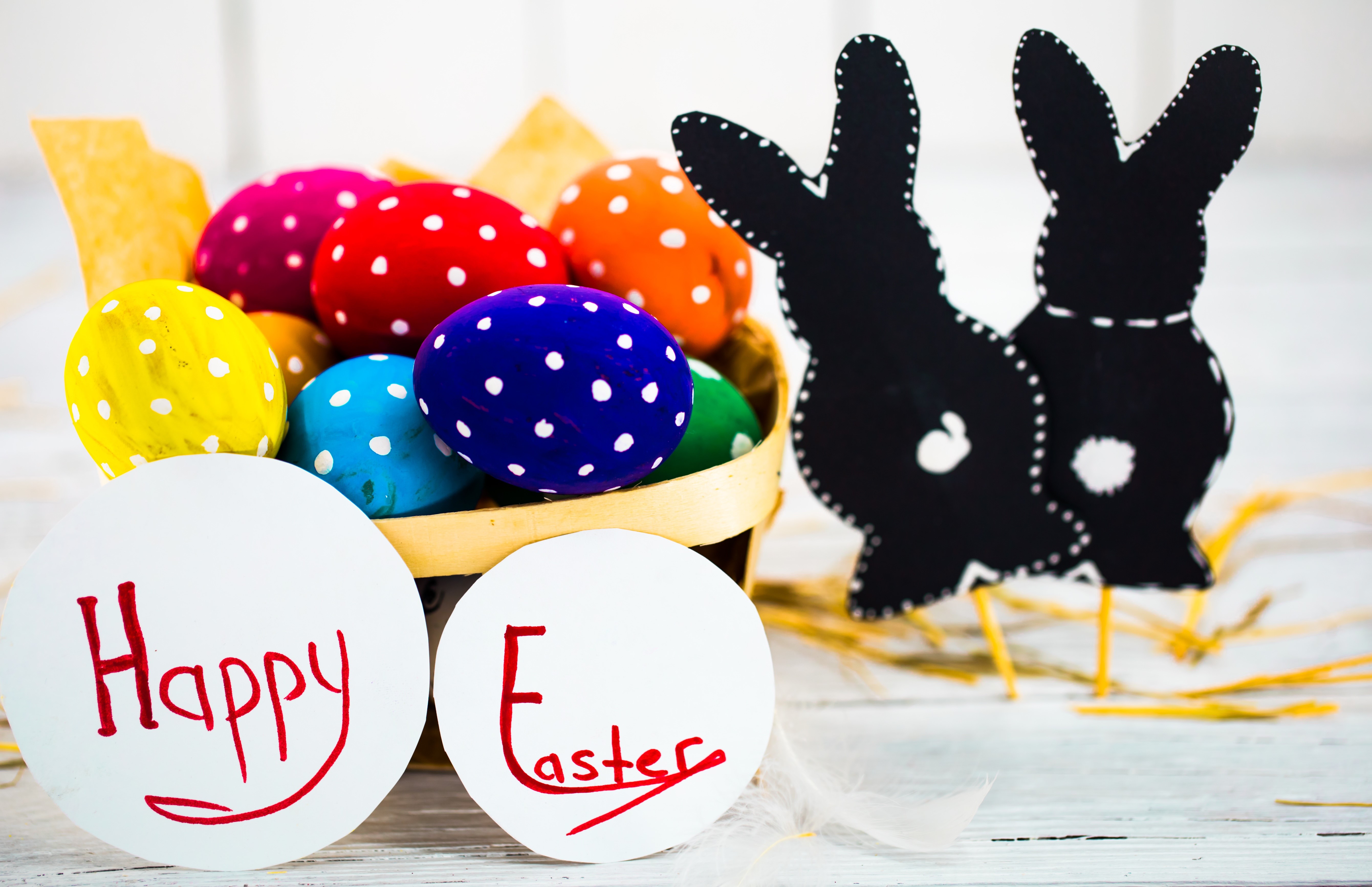 Easter eggs in a basket with bunny decorations and text HD Wallpaper