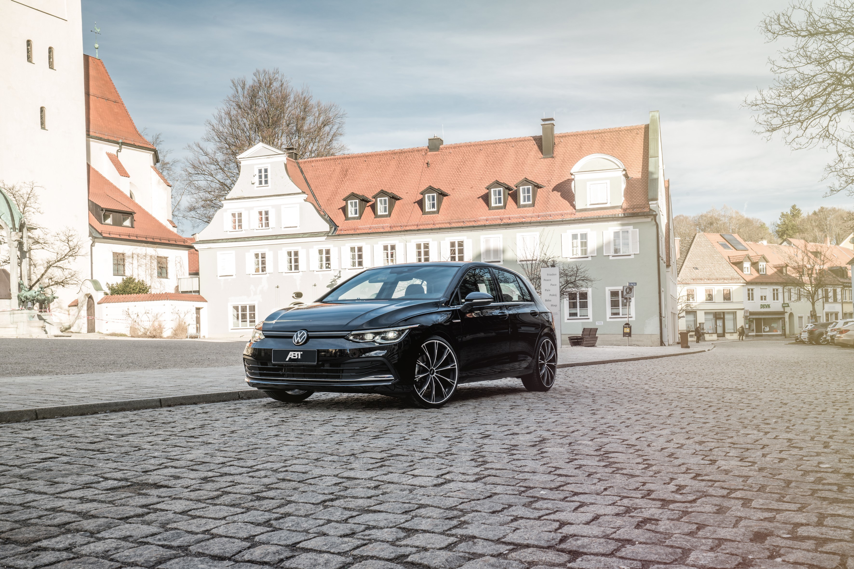 Black ABT Volkswagen Golf on cobblestone street HD Wallpaper