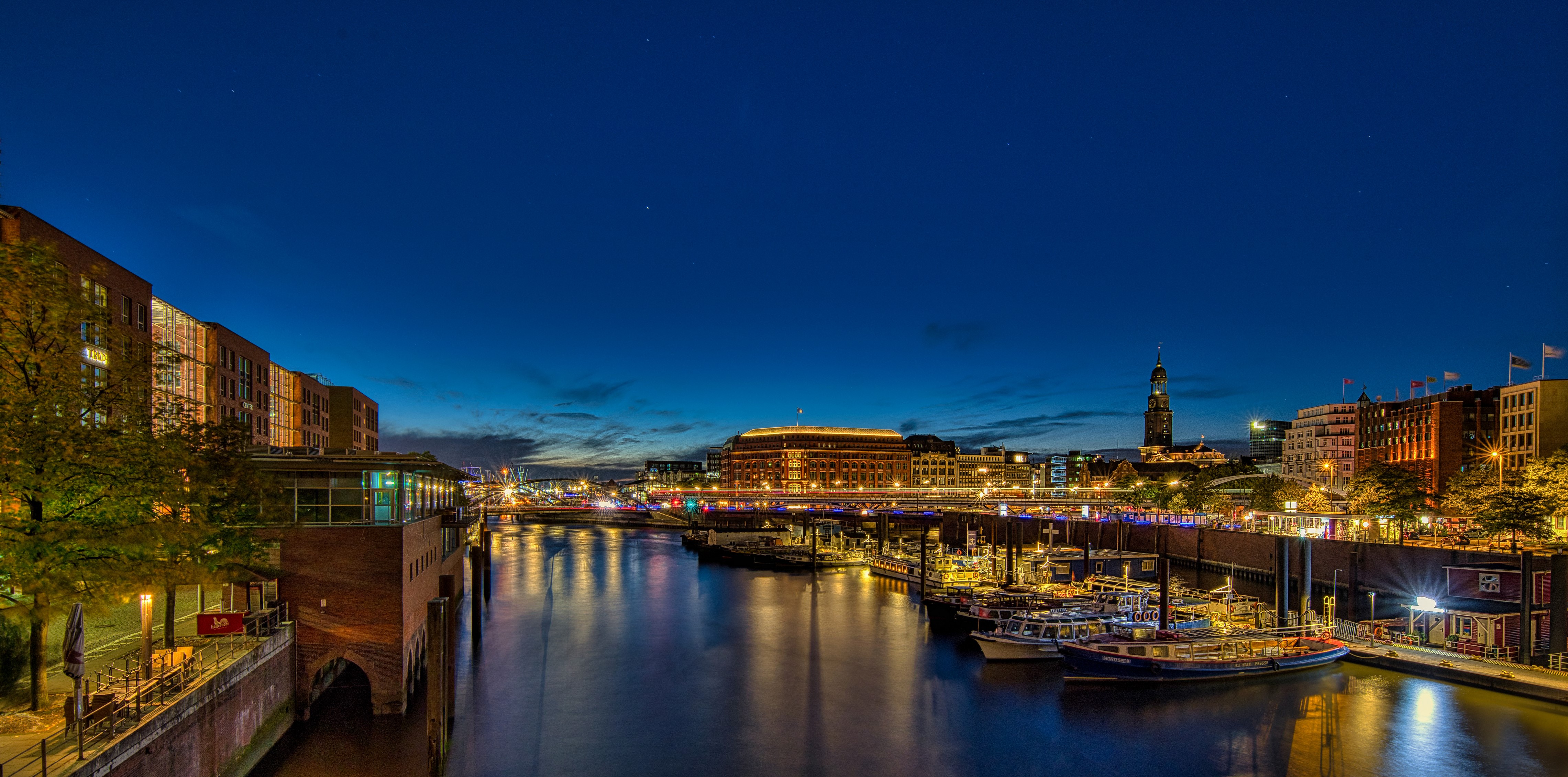 Hamburg harbor at night with boats and buildings HD Wallpaper
