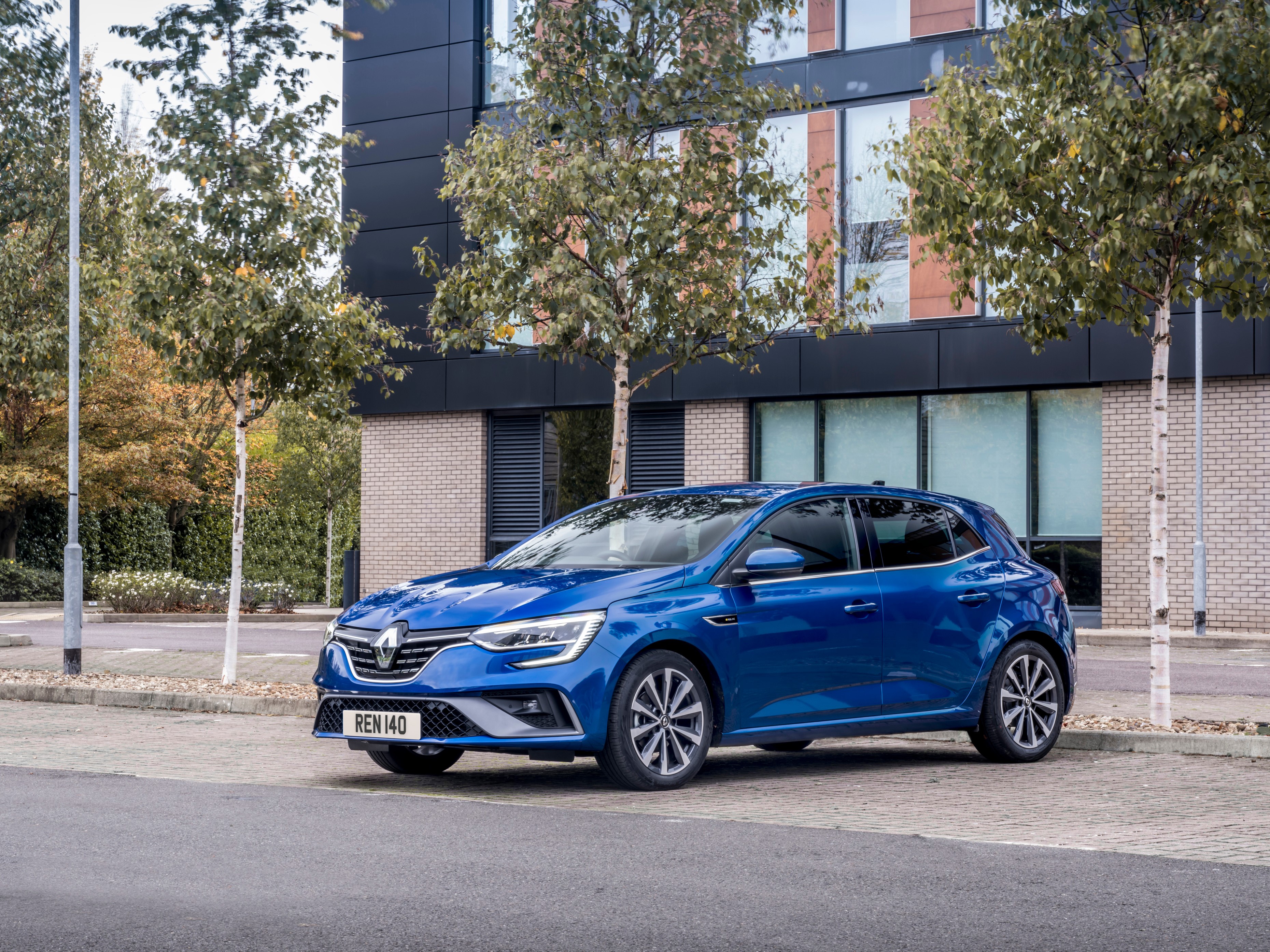 Blue Renault Megane parked in front of a modern building HD Wallpaper