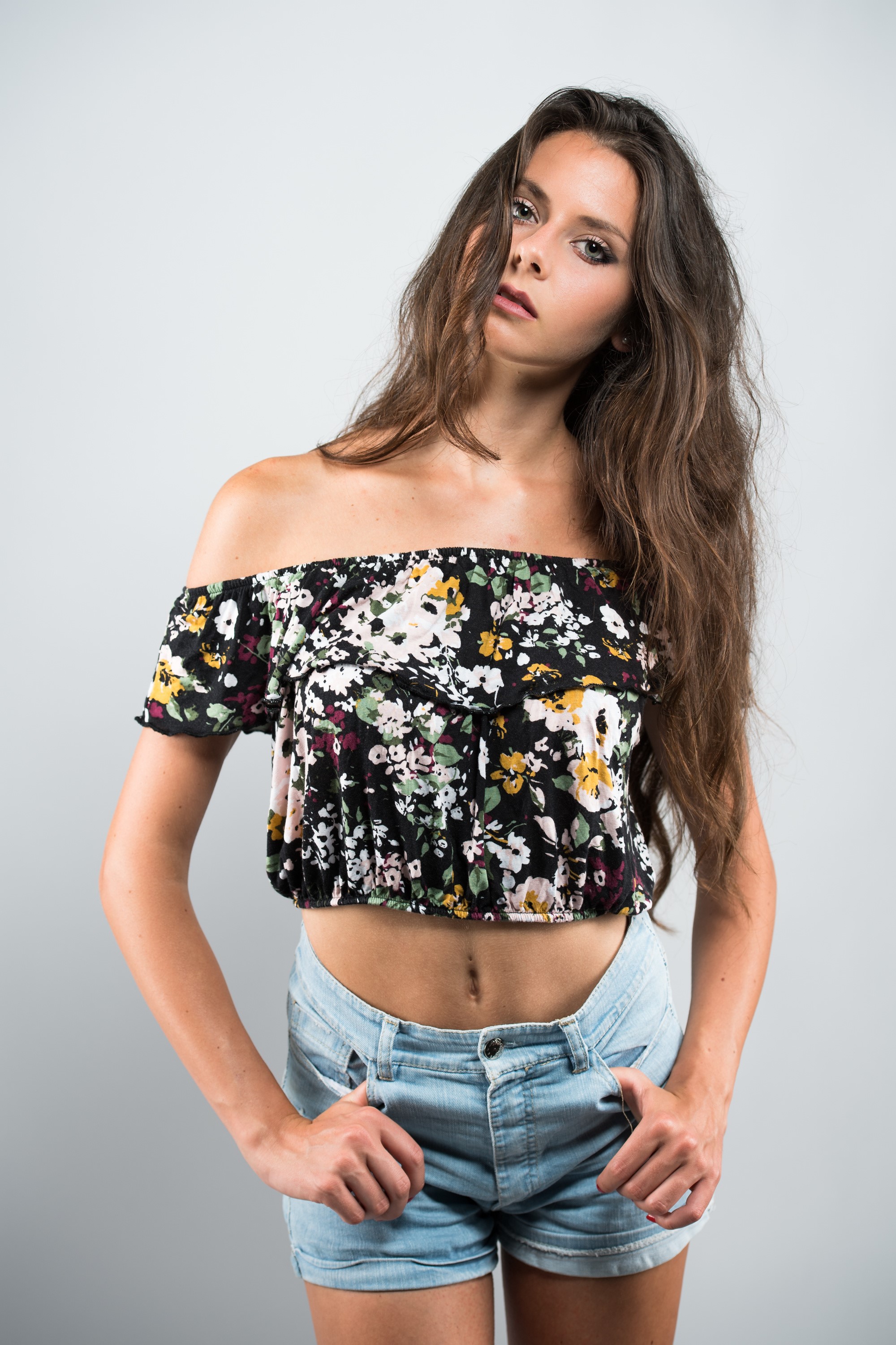 Model in floral off-the-shoulder blouse and denim shorts HD Phone Wallpaper