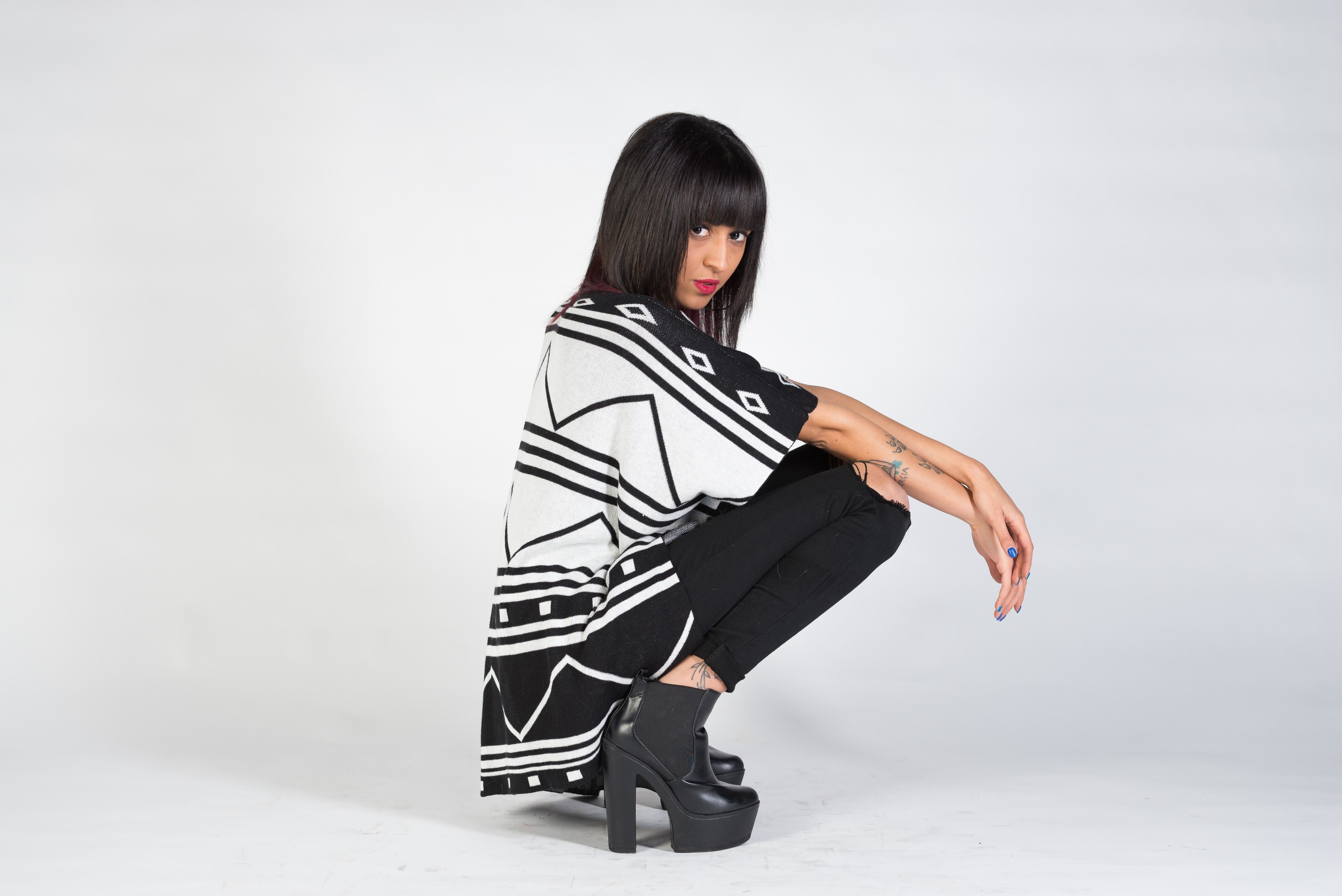 Nadia crouching in a black and white patterned top HD Wallpaper