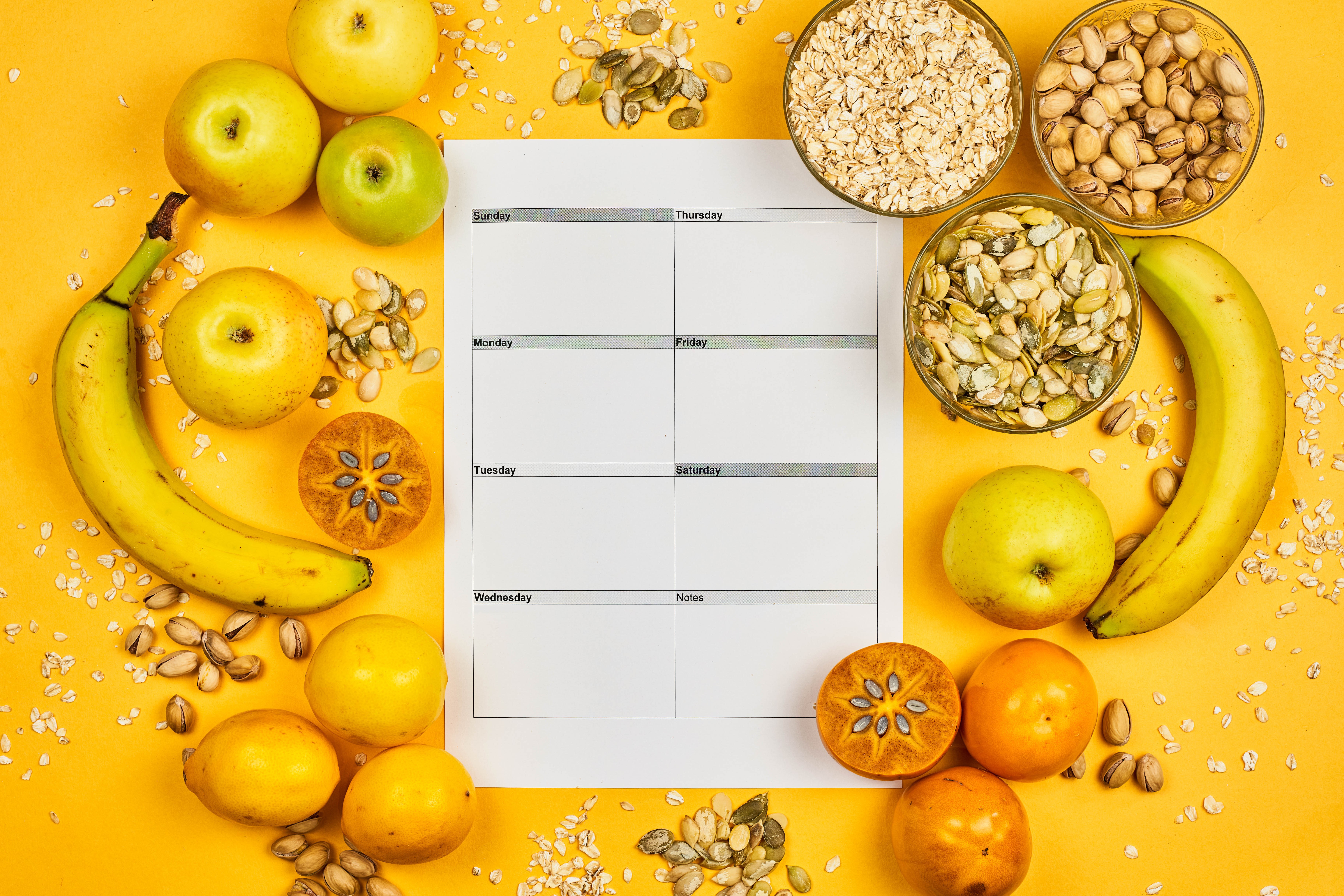Healthy food items arranged around a weekly planner HD Wallpaper