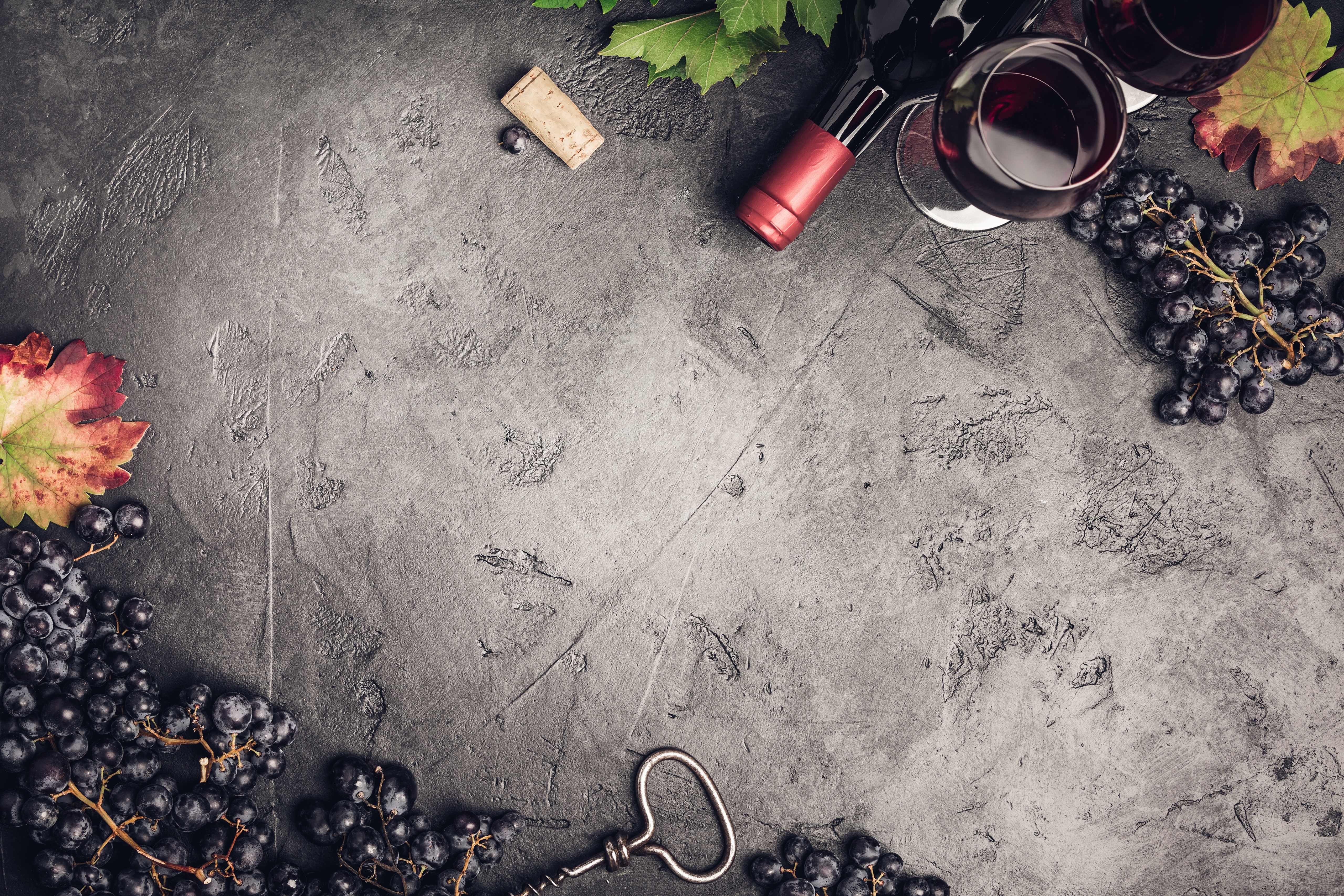 Grapes, Wine Bottle, and Glasses on Textured Surface HD Wallpaper