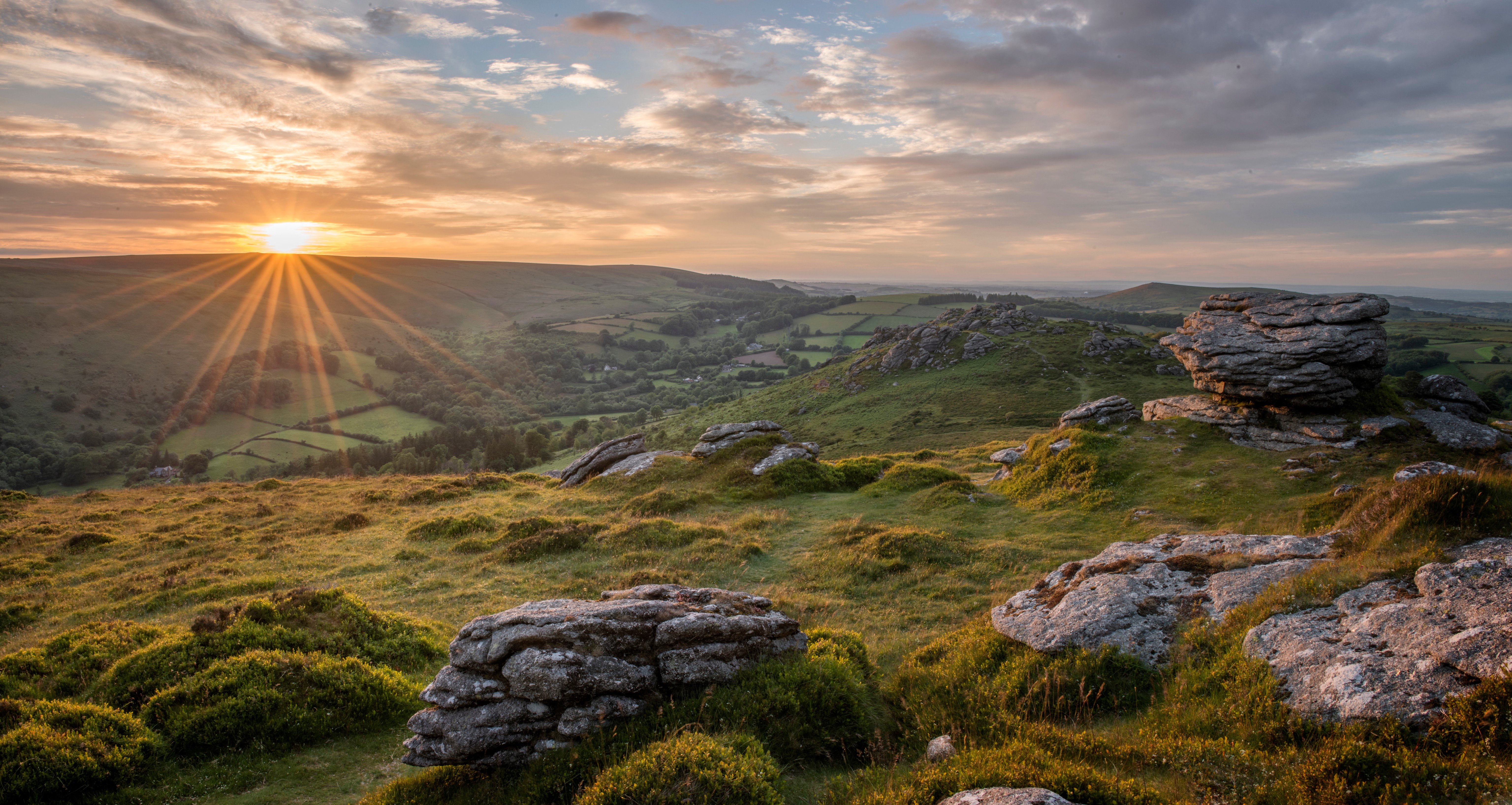 Sunrise over rolling hills with rocks in Devon, England HD Wallpaper