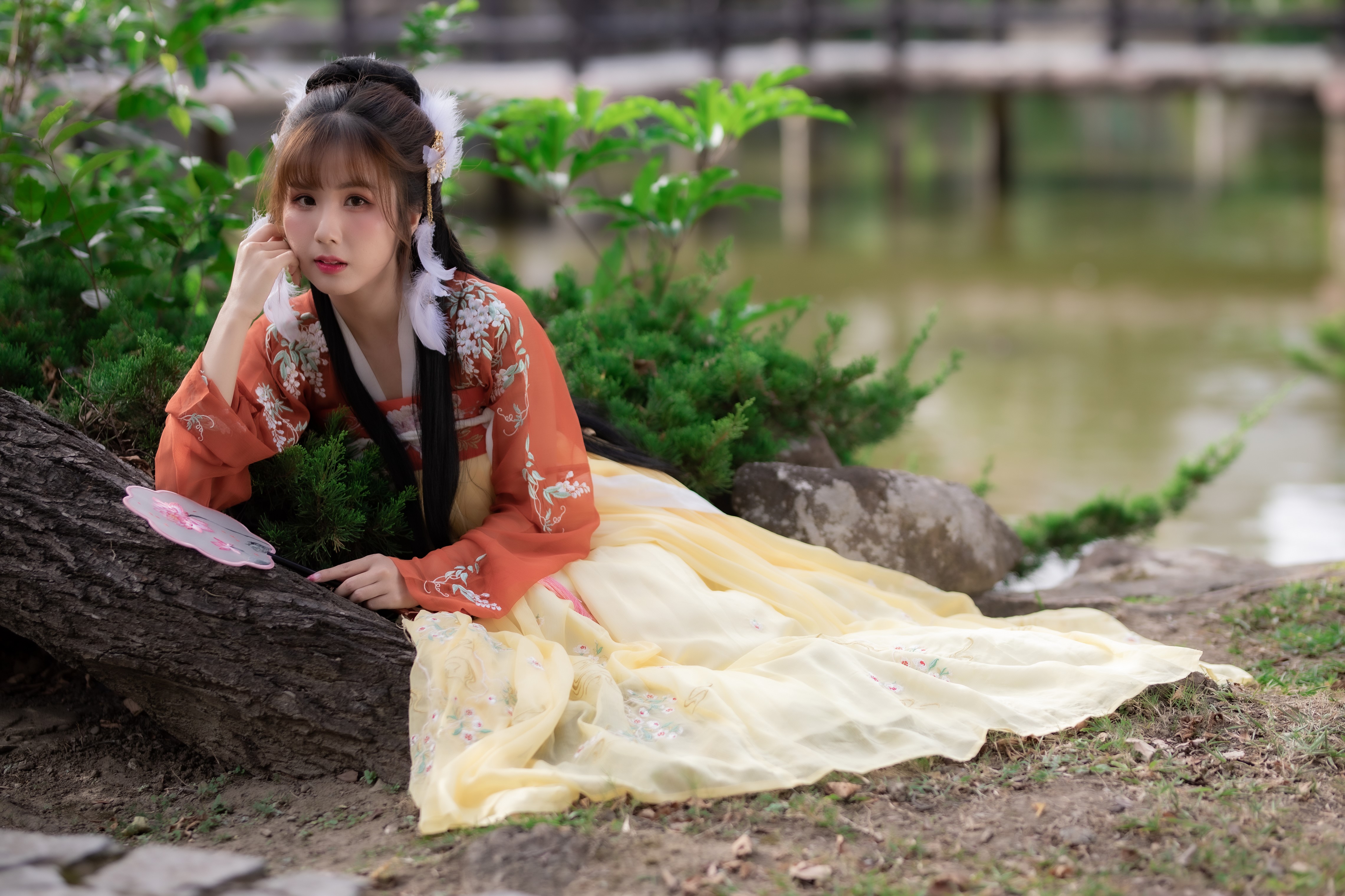 Asian woman in traditional dress posing by a pond HD Wallpaper